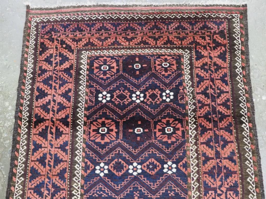 Ancien tapis baloutche de la province de Khorasan en Perse orientale Un tapis baloutche avec une variation du motif mina khani sur un champ bleu indigo foncé.
Circa 1900

Un bon tapis baloutche avec un motif floral de type mina khani, les têtes de