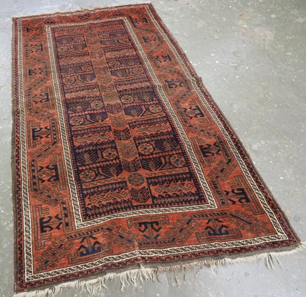 Antico tappeto Baluch proveniente dalla provincia di Khorasan, nella Persia orientale Un tappeto Baluch con uno scarno disegno su un campo blu indaco
Circa 1890

Il tappeto presenta il disegno di un albero totemico, con un ampio tronco che si