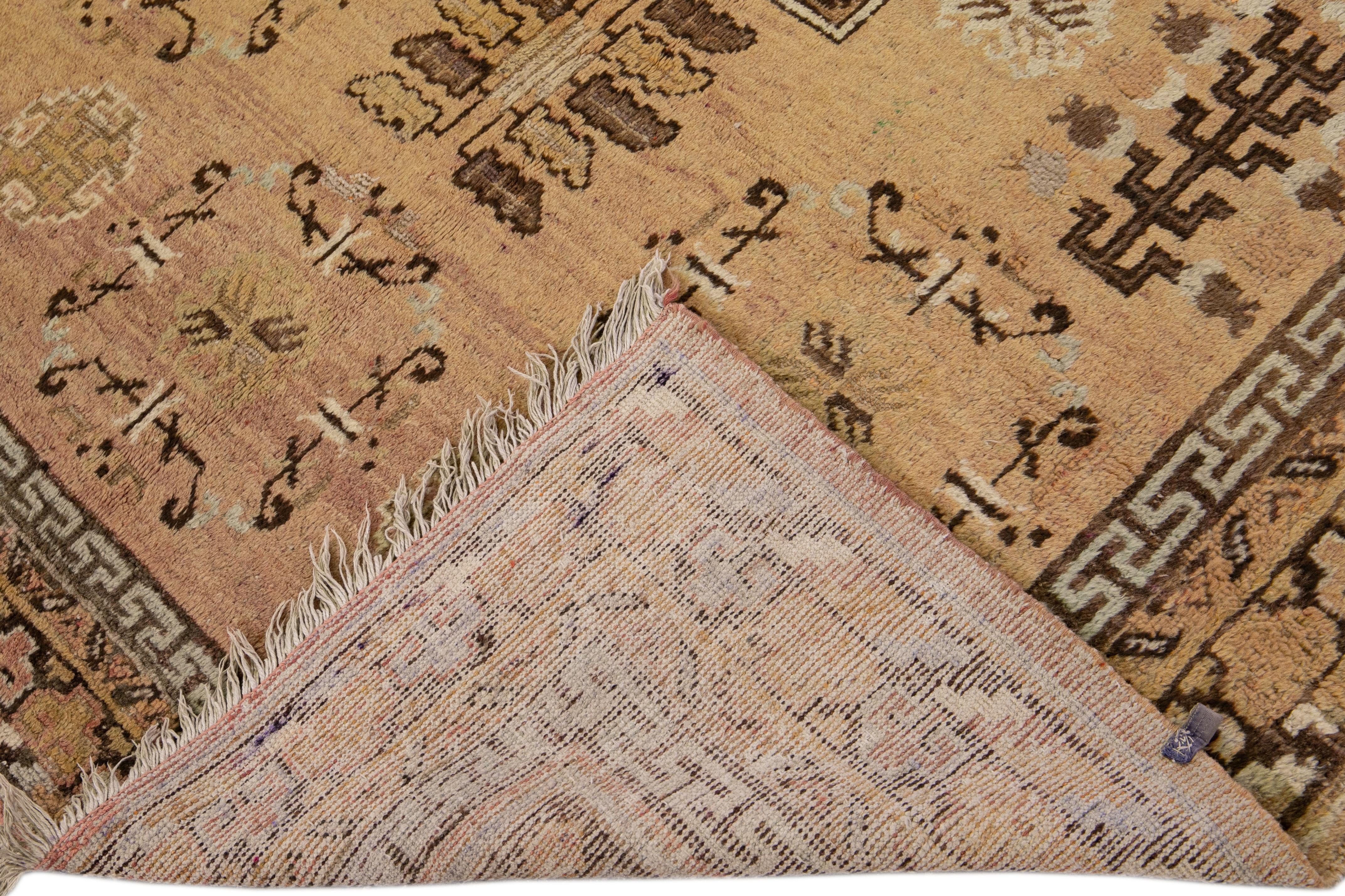 Beautiful antique Khotan hand-knotted wool rug with a Tan field. This Khotan rug has blue, green, and brown accents in all-over geometric design. 

This rug measures 5'10