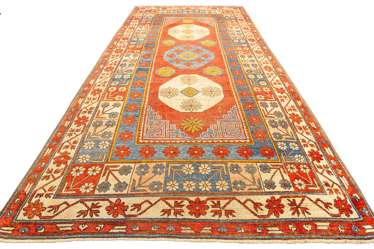 Treten Sie ein in eine Welt von zeitloser Schönheit und kulturellem Reichtum mit unserem antiken Khotan-Teppich. Mit einer beachtlichen Größe von 190 x 335 CM bietet dieser Teppich eine vielfältige Farbpalette mit Rot-, Blau- und Beigetönen sowie