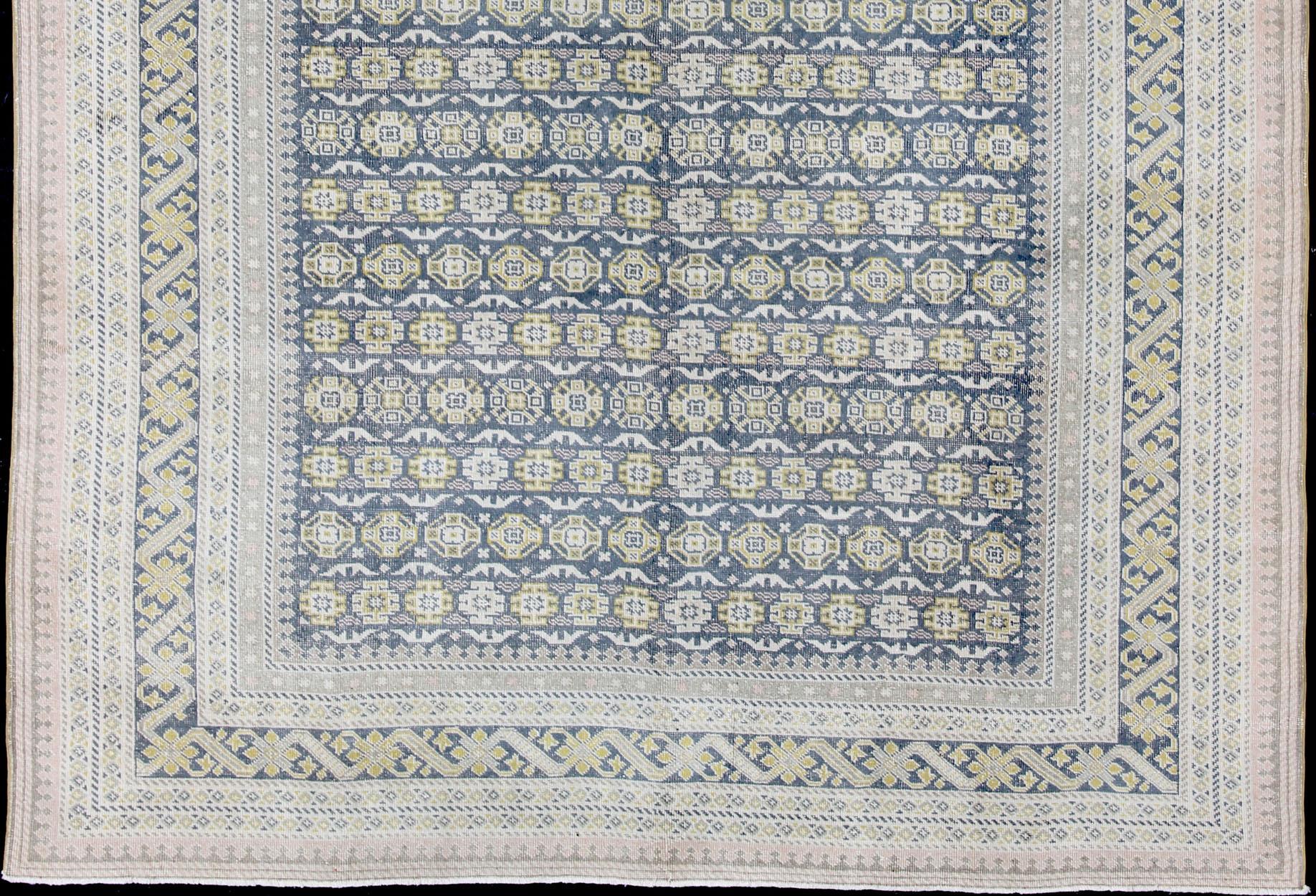 Alfombra antigua Khotan en tonos azules con acentos grises, l. rosas y amarillos Oushak en venta