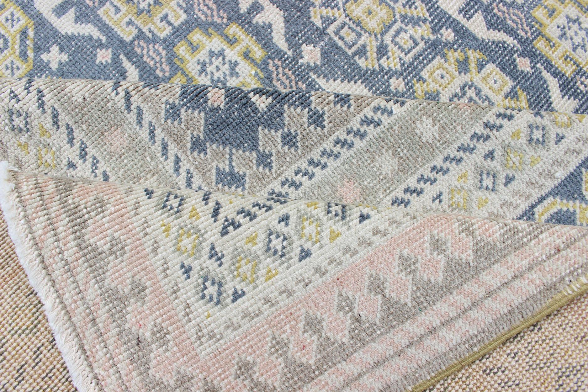 Alfombra antigua Khotan en tonos azules con acentos grises, l. rosas y amarillos Anudado a mano en venta