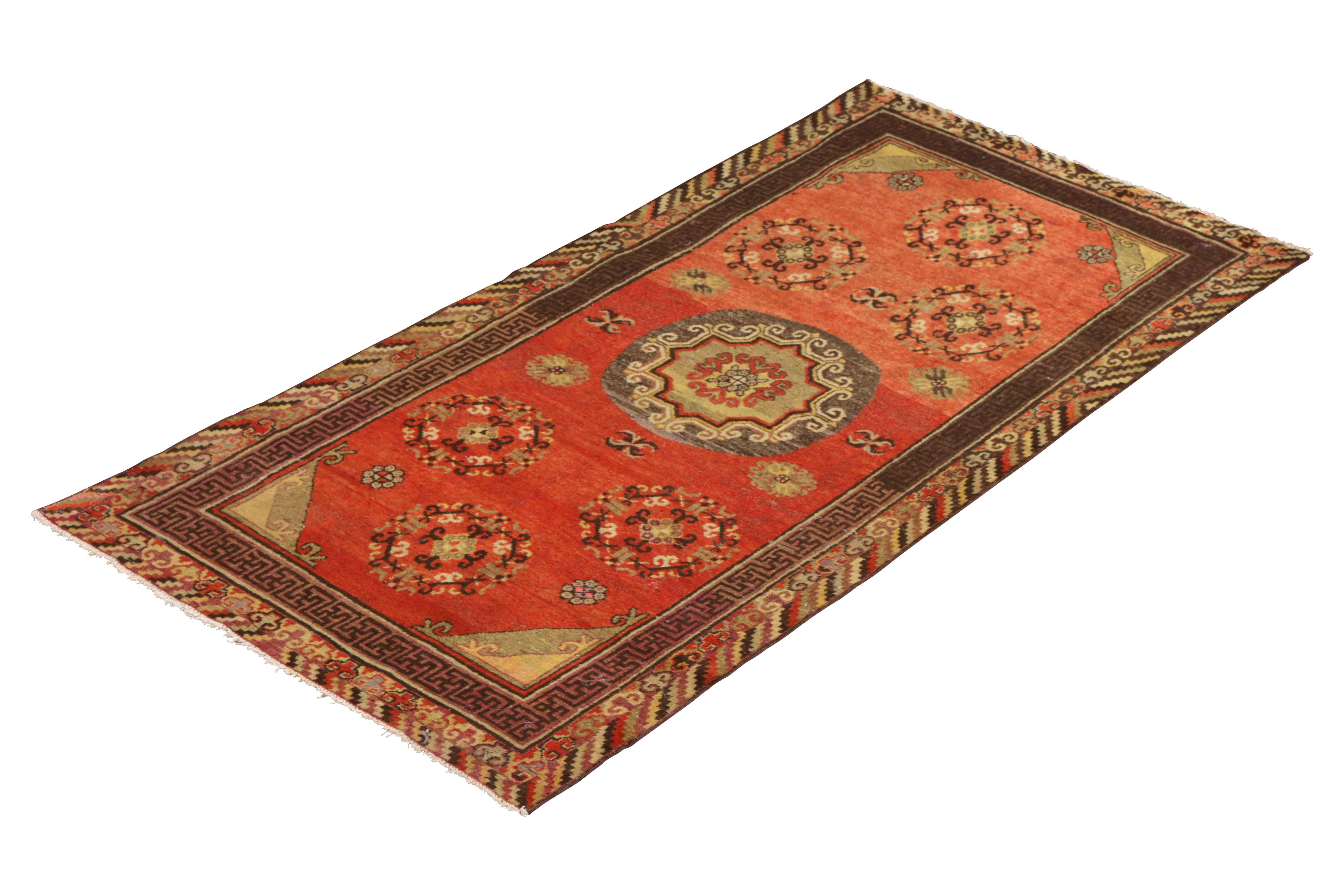 Hand knotted in wool originating from East Turkestan circa 1890-1900, this antique rug connotes a classic Khotan rug design with a classic approach to transitional colorway celebrated in this Oriental rug family. Favoring the cloud band pattern in
