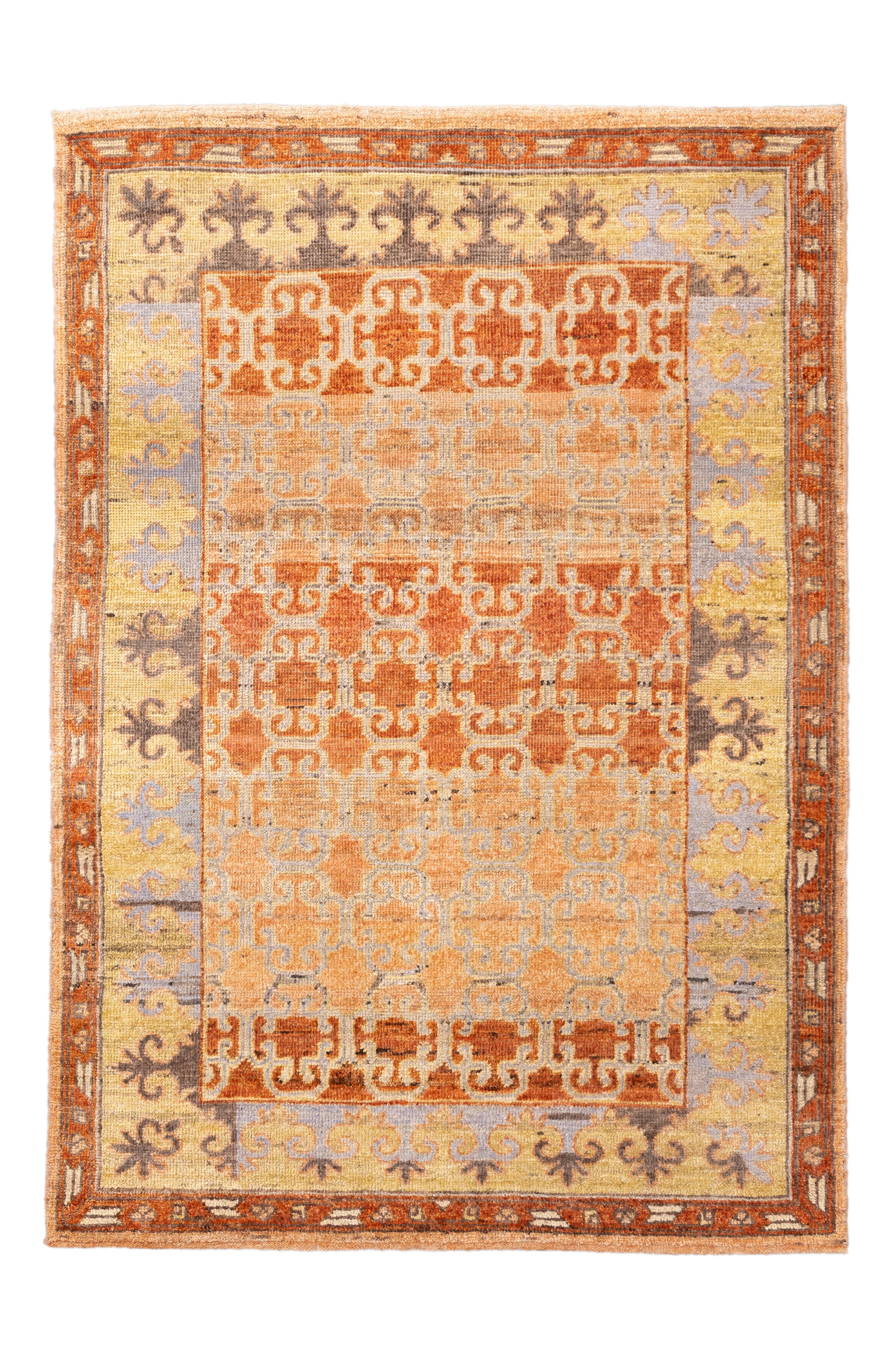  This luminous antique Khotan rug from East Turkestan features a mesmerizing lattice pattern rendered in soft shades of apricot, silver-blue, and ochre. Measuring 4 feet by 6 feet, this piece balances East Asian geometry with Central Asian aesthetic