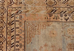 Antique Khotan Rug With Soft Blue Field and Symbolic Motif Design in Tan's