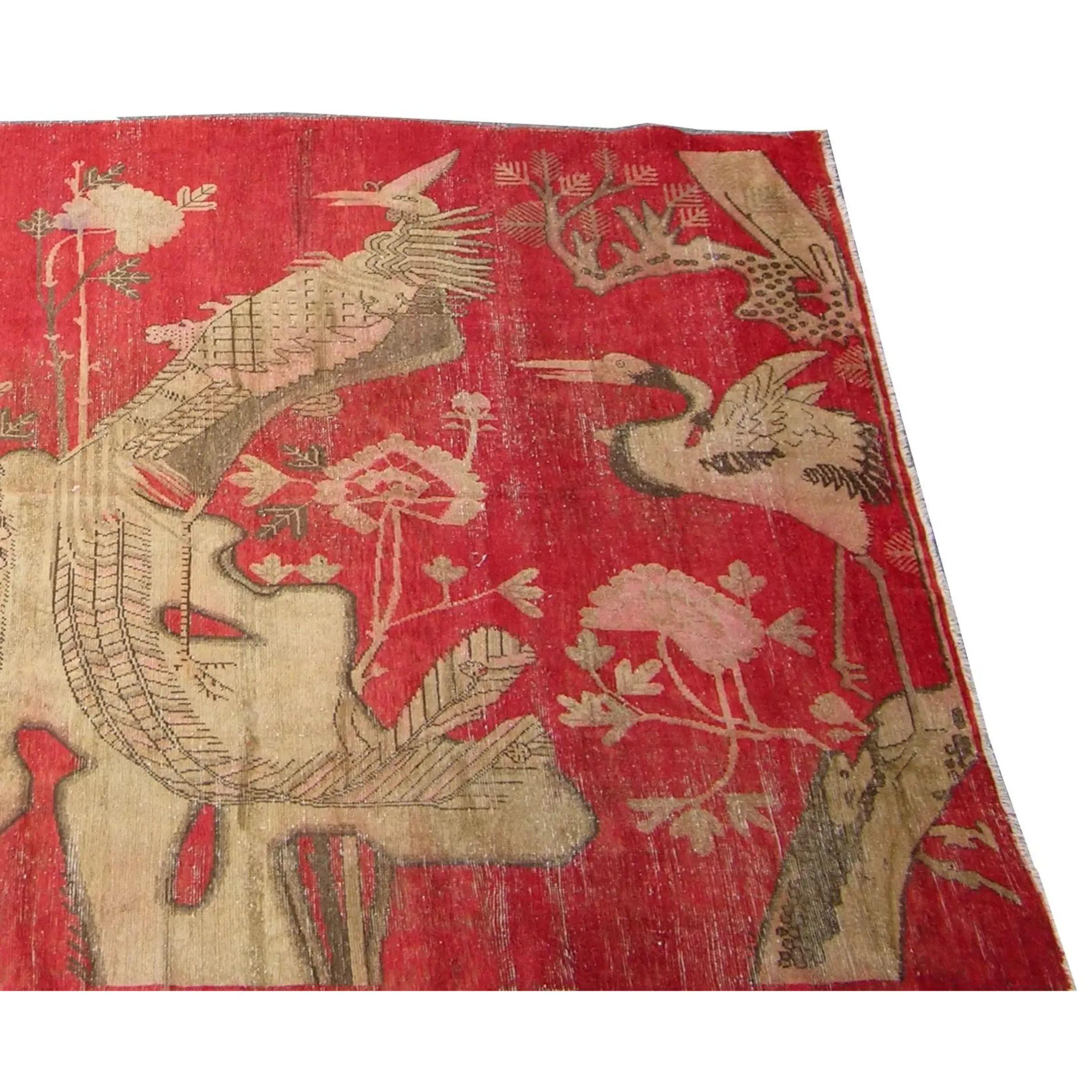 Up&Up est un ancien tapis Khotan Samarkand avec des motifs d'oiseaux sur un fond rouge.