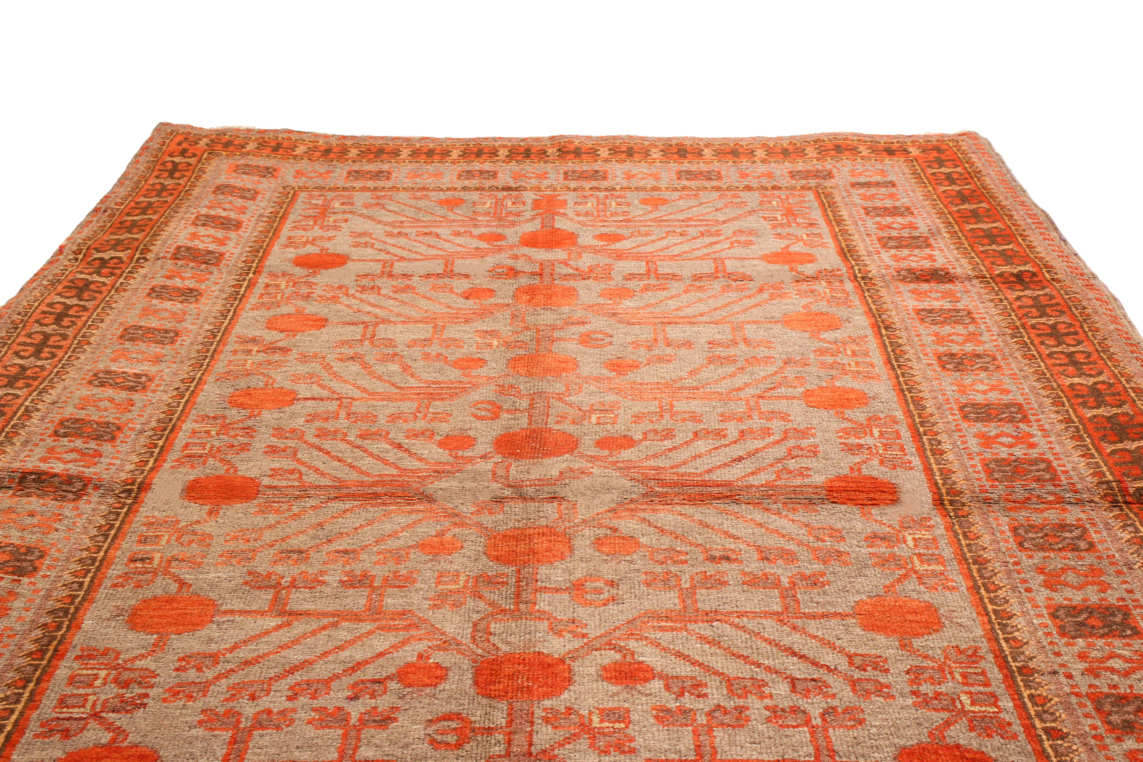 Originating from East Turkestan in 1920s, this antique Khotan rug features an all-over field design, including meaningful regional symbols drawn in a transitional style. Handwoven in high quality wool, the textural light blue field features