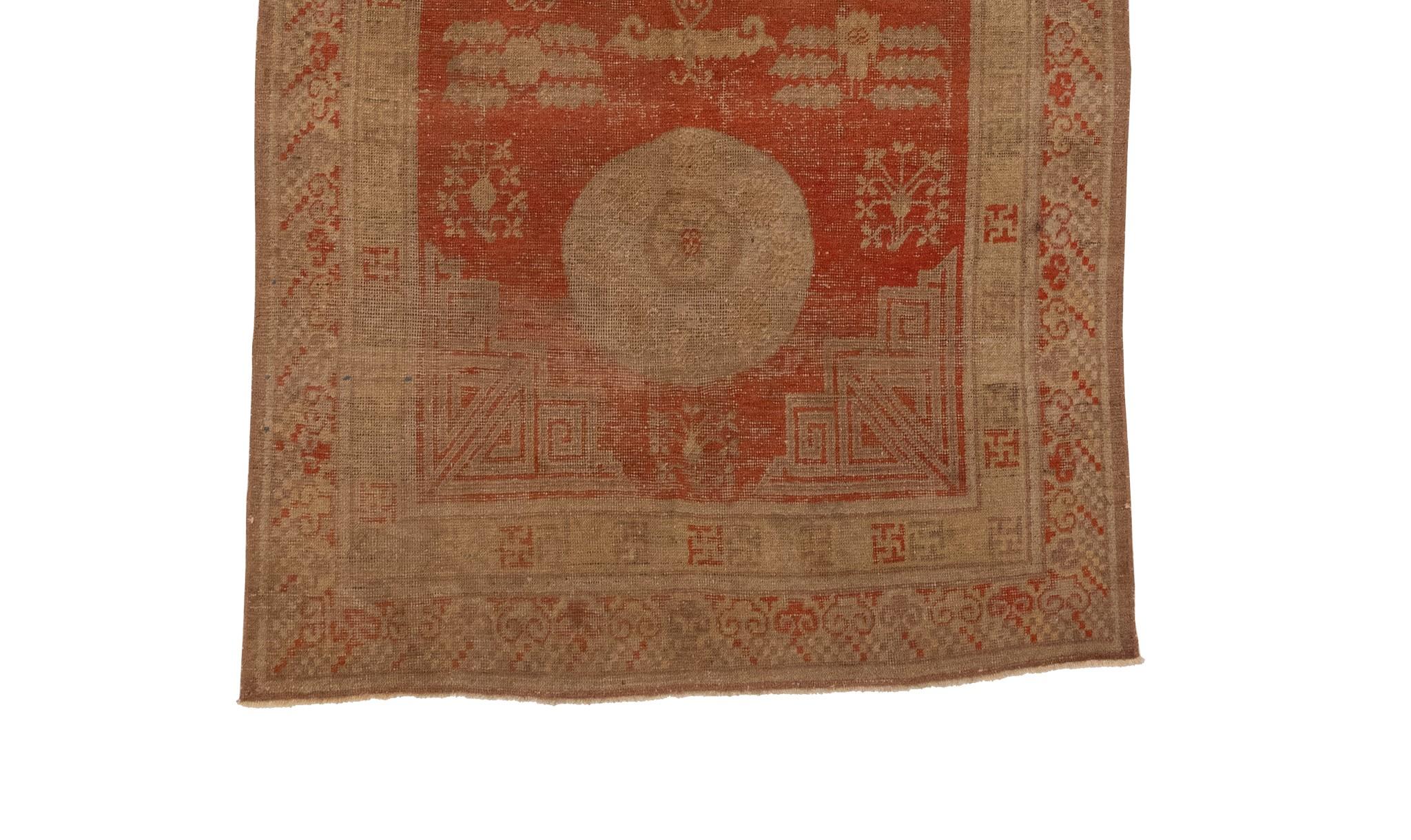 Here we have an antique Khotan rug from East Turkistan, made around 1900. This rug is a stunning example of the early rugs created in this area. It features three captivating circular medallions, each with a unique design and placement that adds to