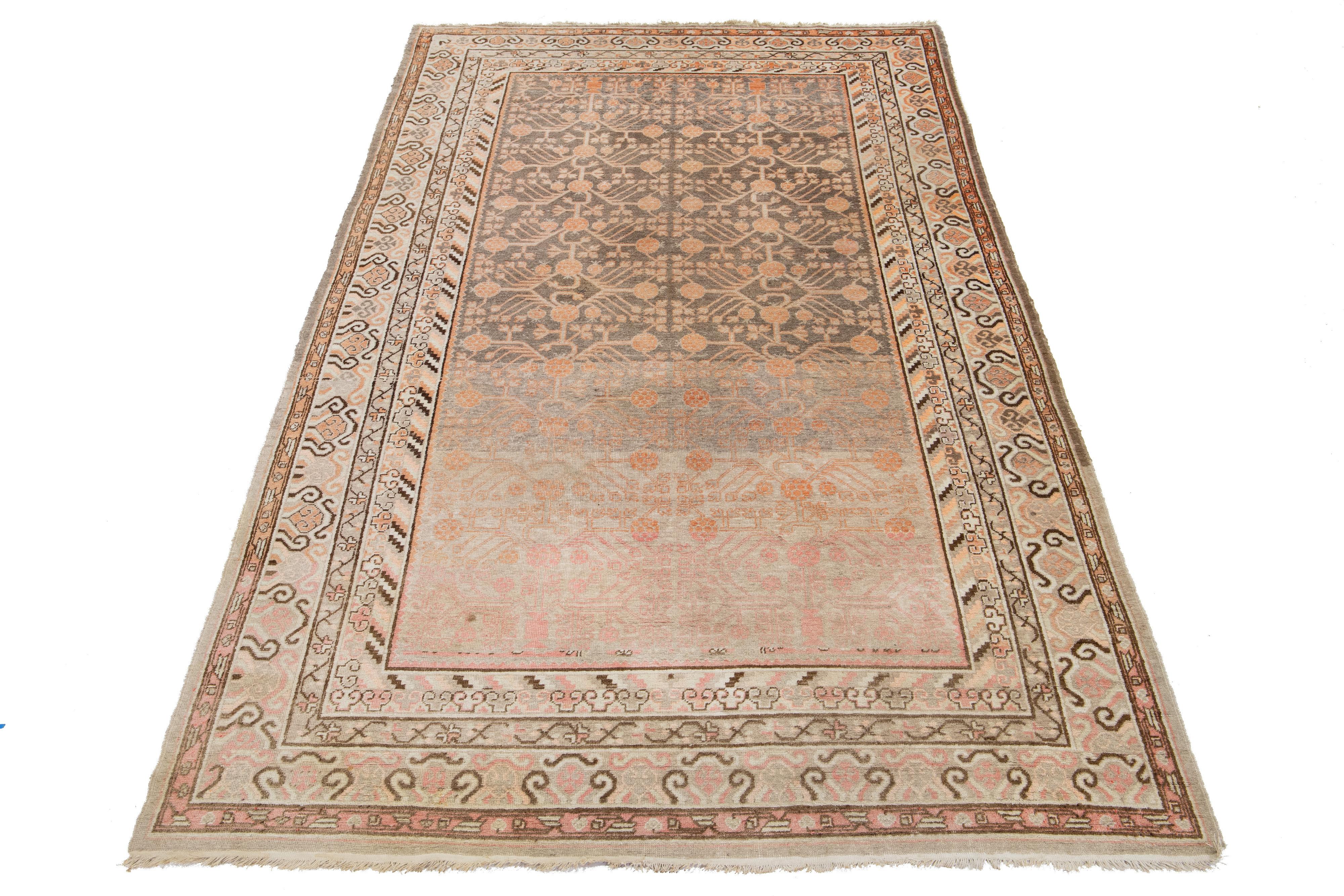 Bellissimo tappeto antico in lana Khotan annodato a mano con campo grigio. Questo Khotan presenta accenti color pesca e marrone in uno splendido motivo floreale a medaglione all-over.

Questo runner misura 6'9'' x 12'11''.