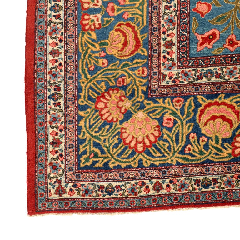 This antique Khoy Persian carpet in blue, red and green circa 1920 is 13' x 20' and features a curvilinear central medallion and intricate multi-banded border. Commissioned by the order of Reza Shah from the workshop of master weaver Javan, this