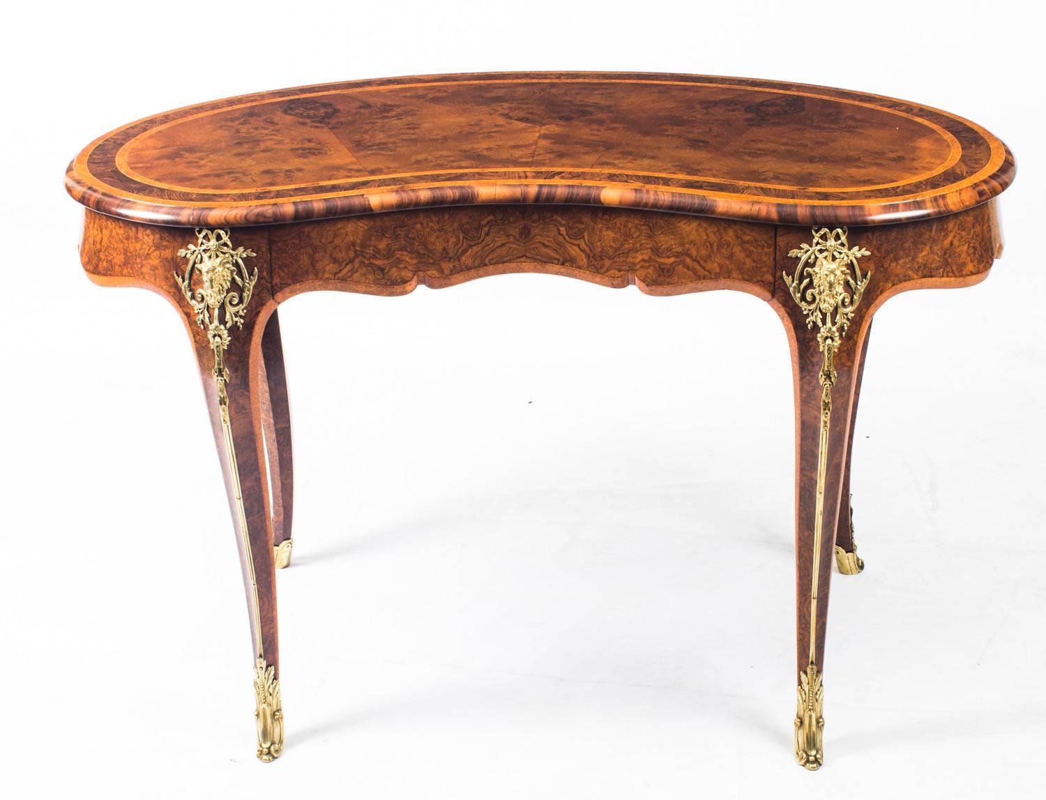 This is a fabulous quality antique burr walnut and amboyna kidney shaped writing table, circa 1850 in date.

The writing table features fabulous decorative ormolu mounts, amboyna crossbanded decoration and a single drawer that is stamped with the