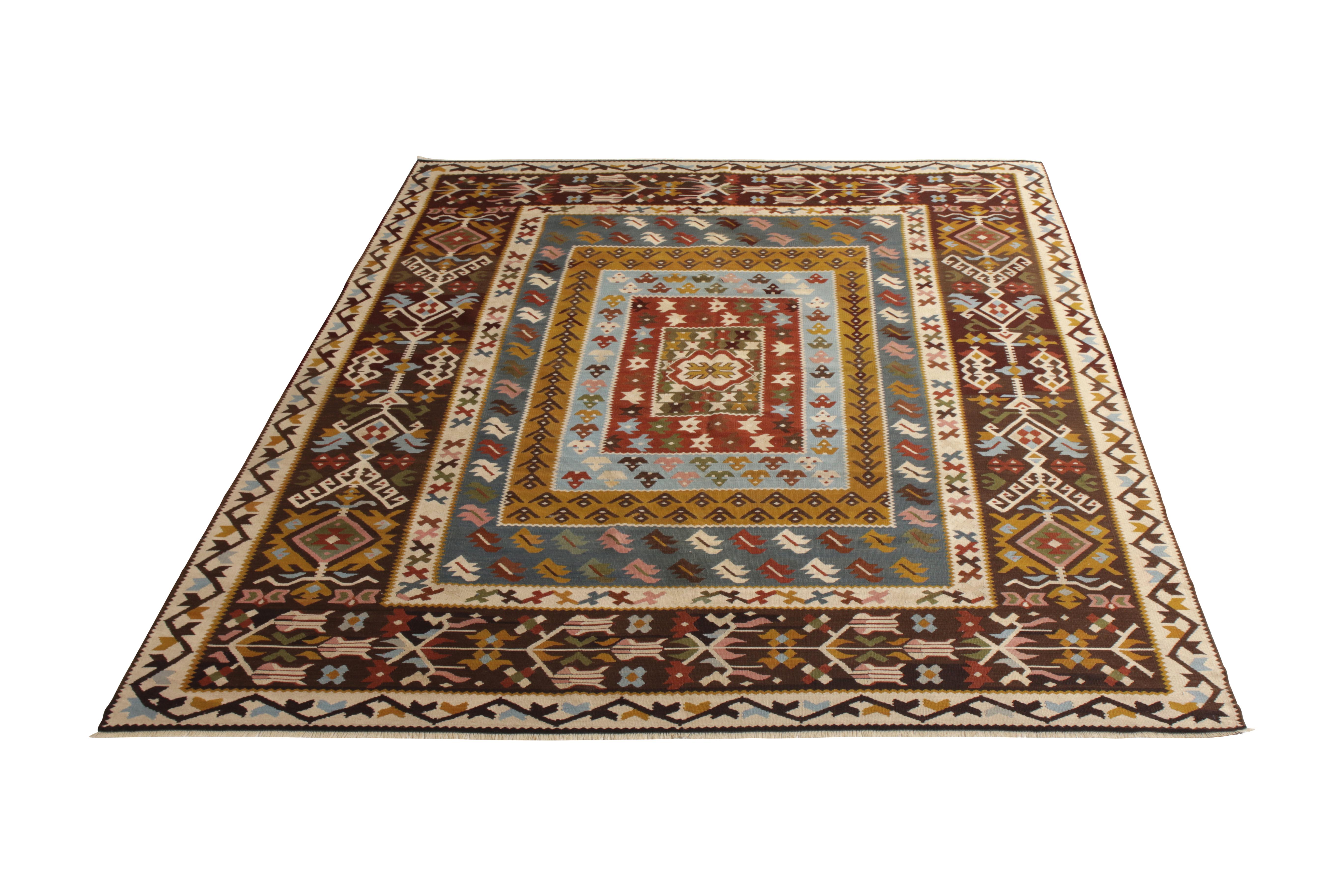 Handmade in flat-woven wool originating from Turkey circa 1920, this vintage rug is a mid-century Kilim rug of a dynamic nature, suspected to be of Albanian design influence in employing exciting accenting colors in the prevailing beige-brown and