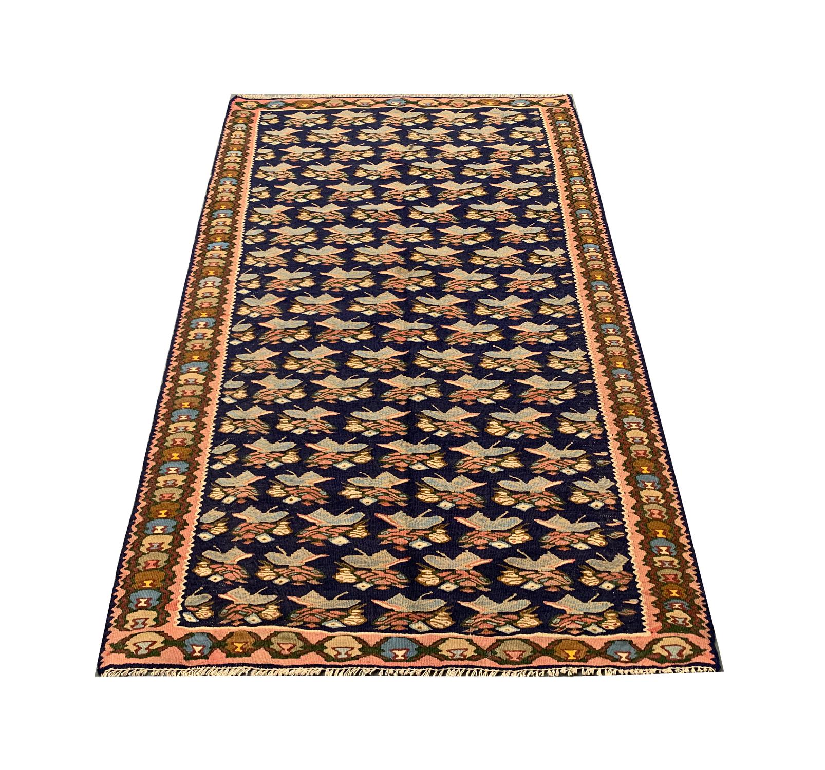 This beautiful antique Caucasian rug has been woven with a fantastic all-over design with a blue background and green, brown and cream accents that make up the repeat floral pattern. A repeat pattern border then encloses this simple yet elegant
