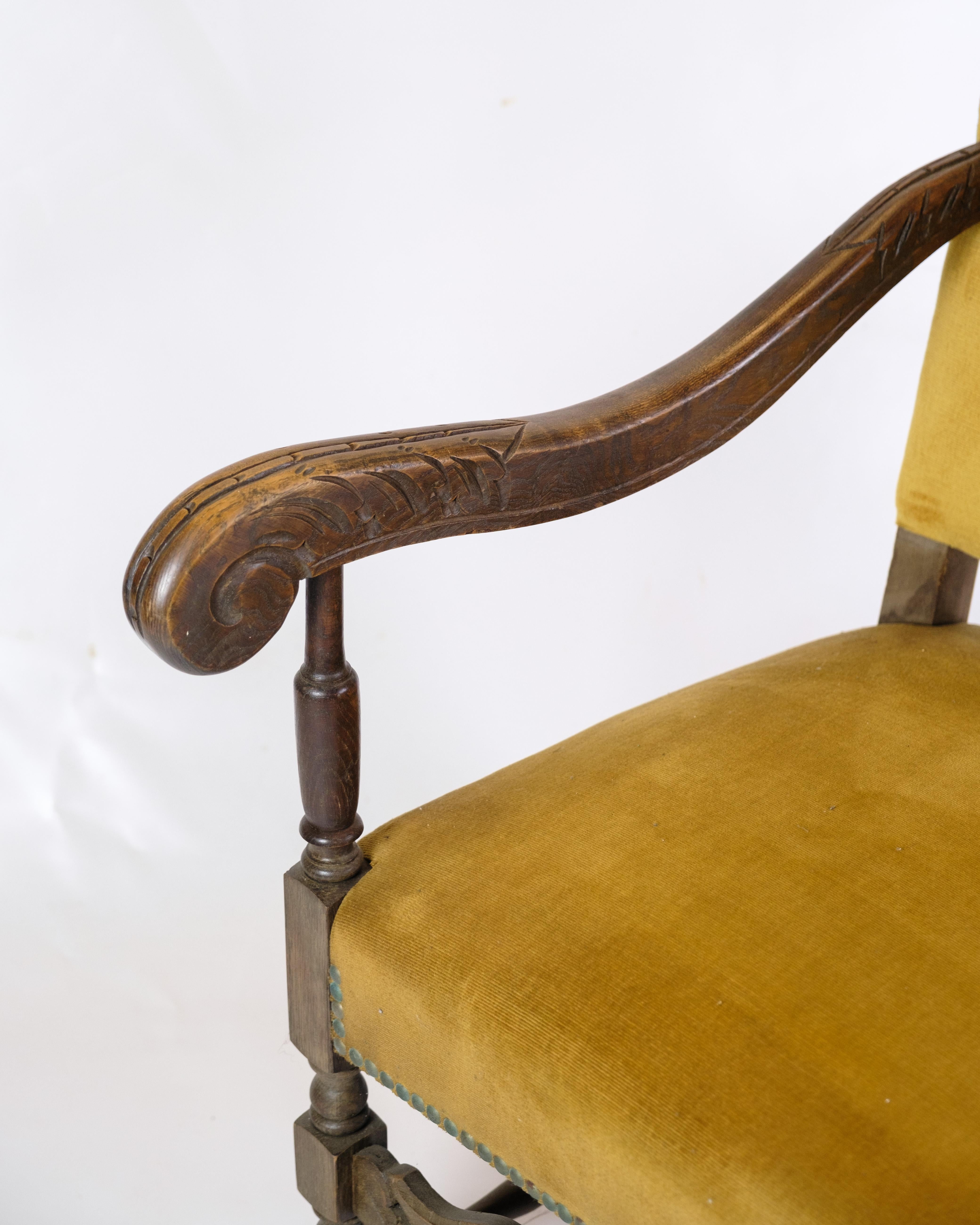 This antique king chair is a breathtaking representation of furniture history from the 1920s. Upholstered in yellow stitched velor, this chair exudes a regal elegance and a finesse typical of the period.

The most striking feature of this chair is