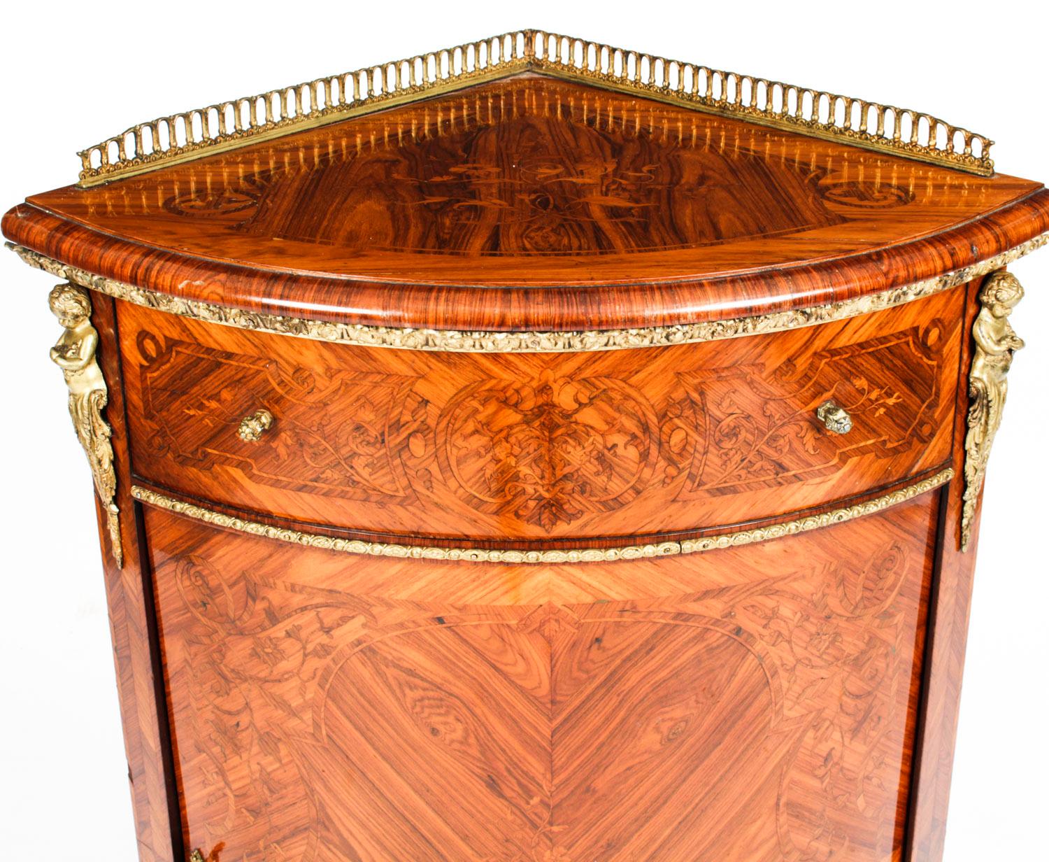 This is a fabulous antique French ormolu mounted kingwood and walnut marquetry low bowfront corner cabinet, circa 1860 in date.

The cabinet is profusely inlaid with a floral marquetry decoration by a master craftsman, it has superb floral