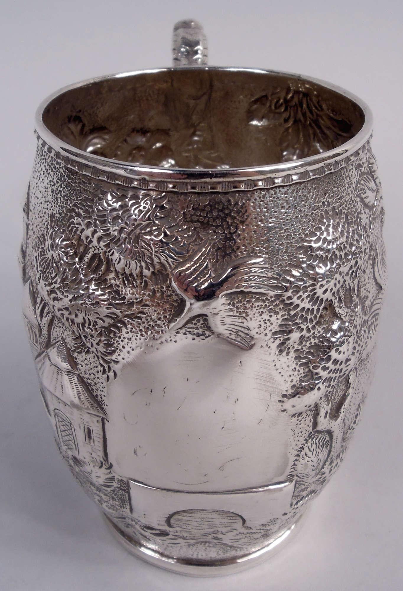 Tazza vittoriana in argento per bambini. Prodotto da S. Kirk & Son a Baltimora. Forma a barile con lati curvi; maniglia a staffa con cappuccio a forma di foglia e volute. Scena pastorale con torri circondate da fiori e alberi; cartiglio (vuoto) con
