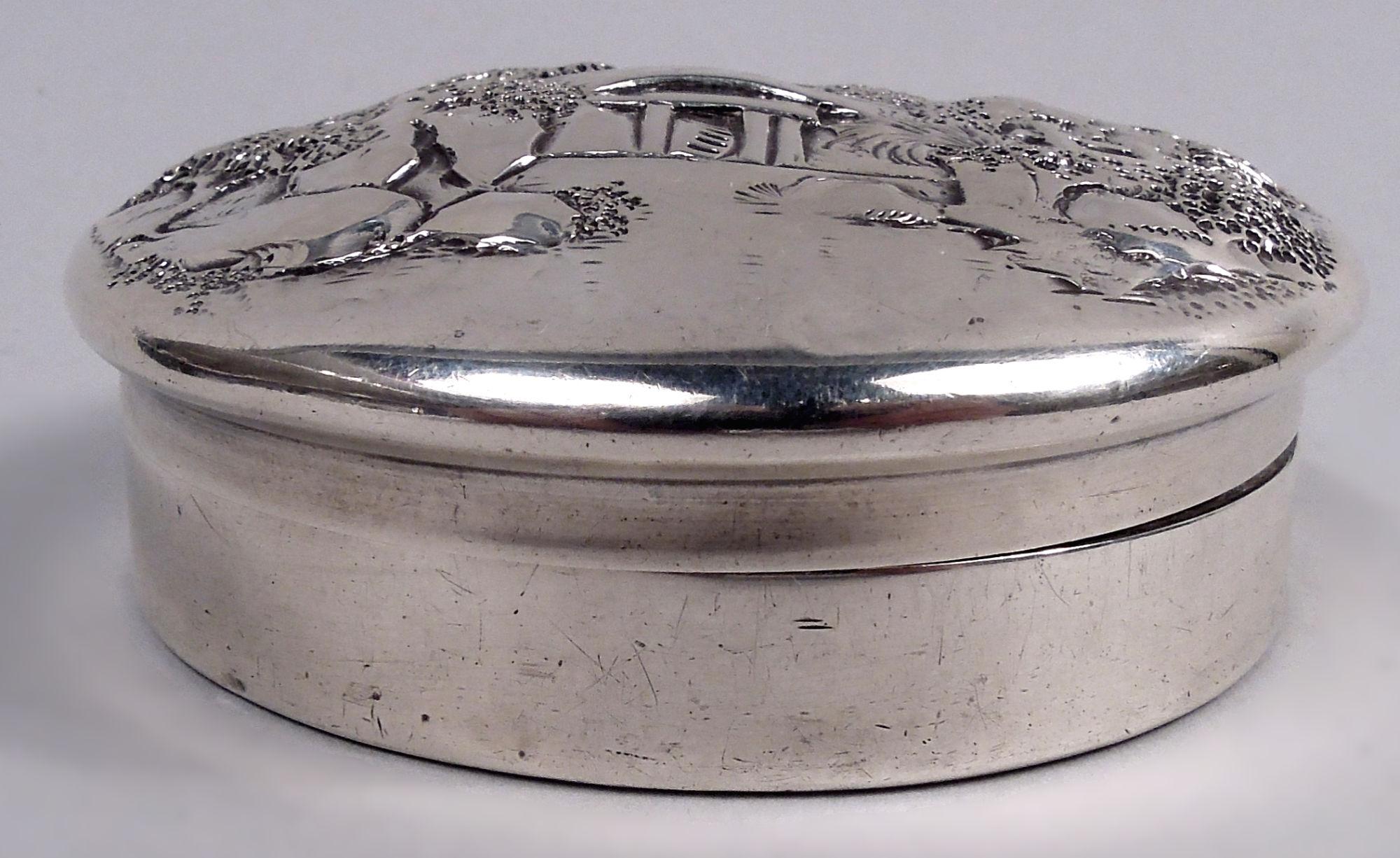 Edwardian sterling silver box. Made by S. Kirk & Son Co. in Baltimore, ca 1910. Round with straight sides. Cover raised and overhanging with pictorial pastoral scene: A watermill in bosky surround, with bird flying overhead. Fully marked including
