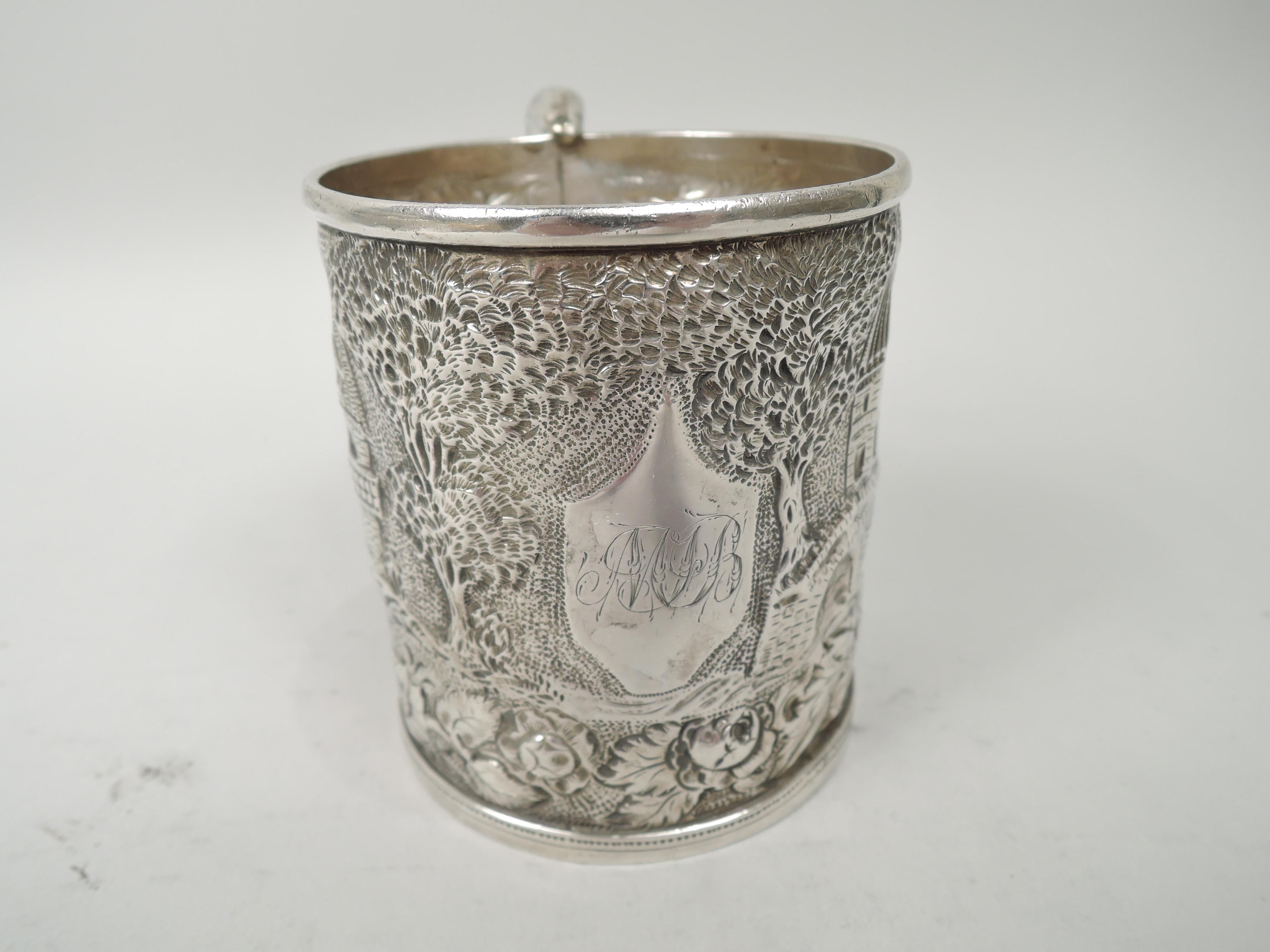 Victorian silver baby cup. Made by S. Kirk & Son in Baltimore, ca 1870. Drum form with plain rim. Foot same with beaded and linear borders. Double-scroll handle with engraved feathering. Repousse landscape with vernacular buildings and bridge.