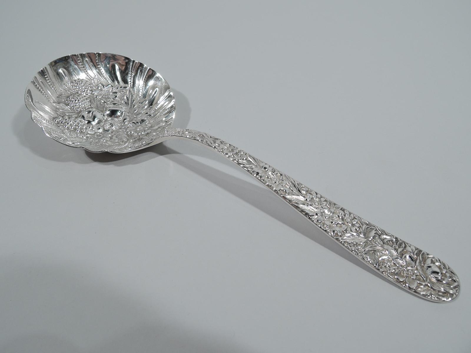 Antique Repousse sterling silver berry spoon. Made by S. Kirk & Son in Baltimore. Dense low-relief flowers on tapering stem. Bowl round and crimped with repousse flowers, berries, and other fruit. A good working piece in the historic pattern.