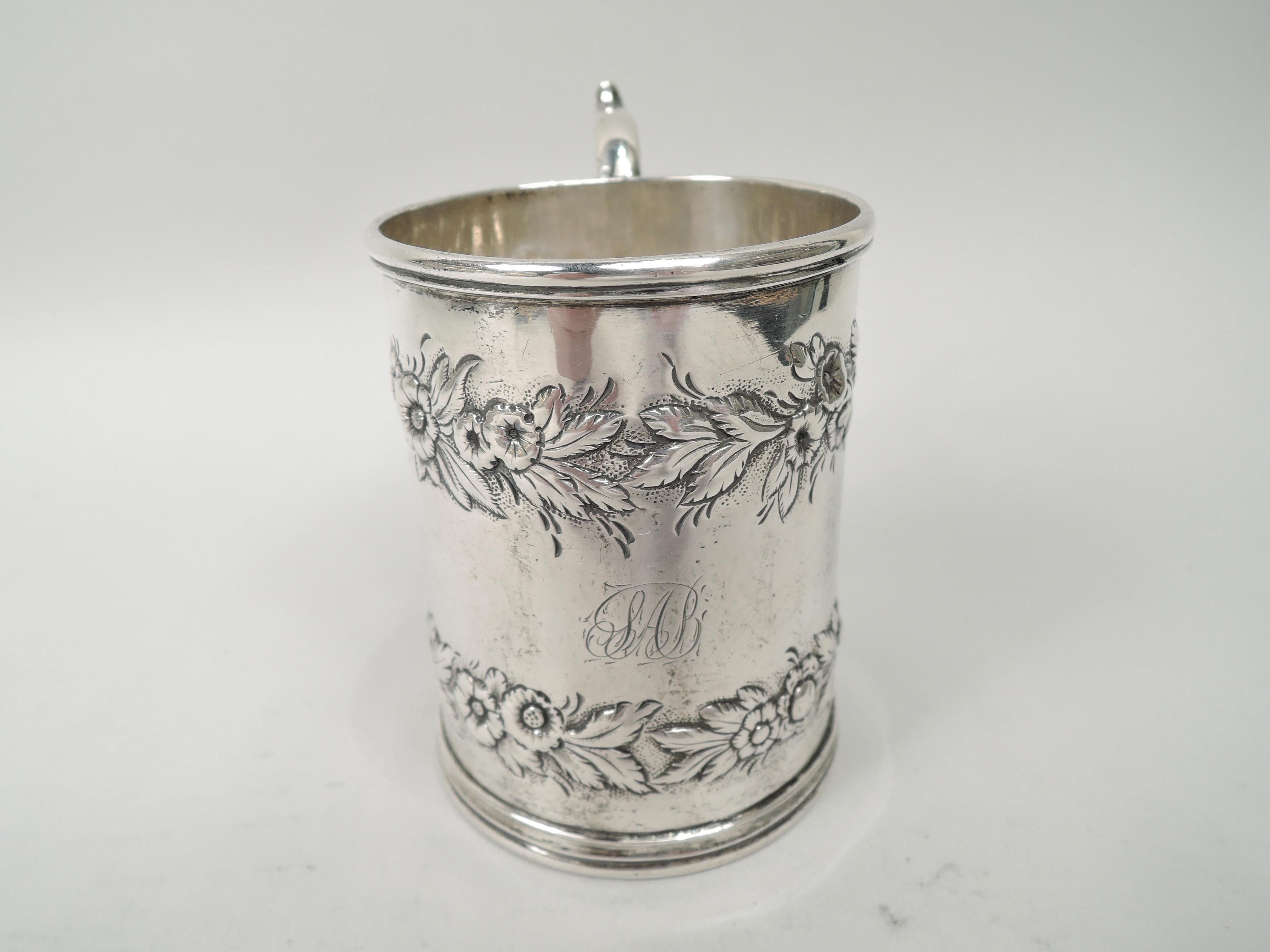 Victorian silver baby cup. Made by S. Kirk, ca 1840. Gently upward tapering sides, molded rims, and leaf-capped double-scroll handle. Two chased floral garlands. Engraved script monogram. Marks include maker’s stamp (1830-46). Weight: 4.7 troy