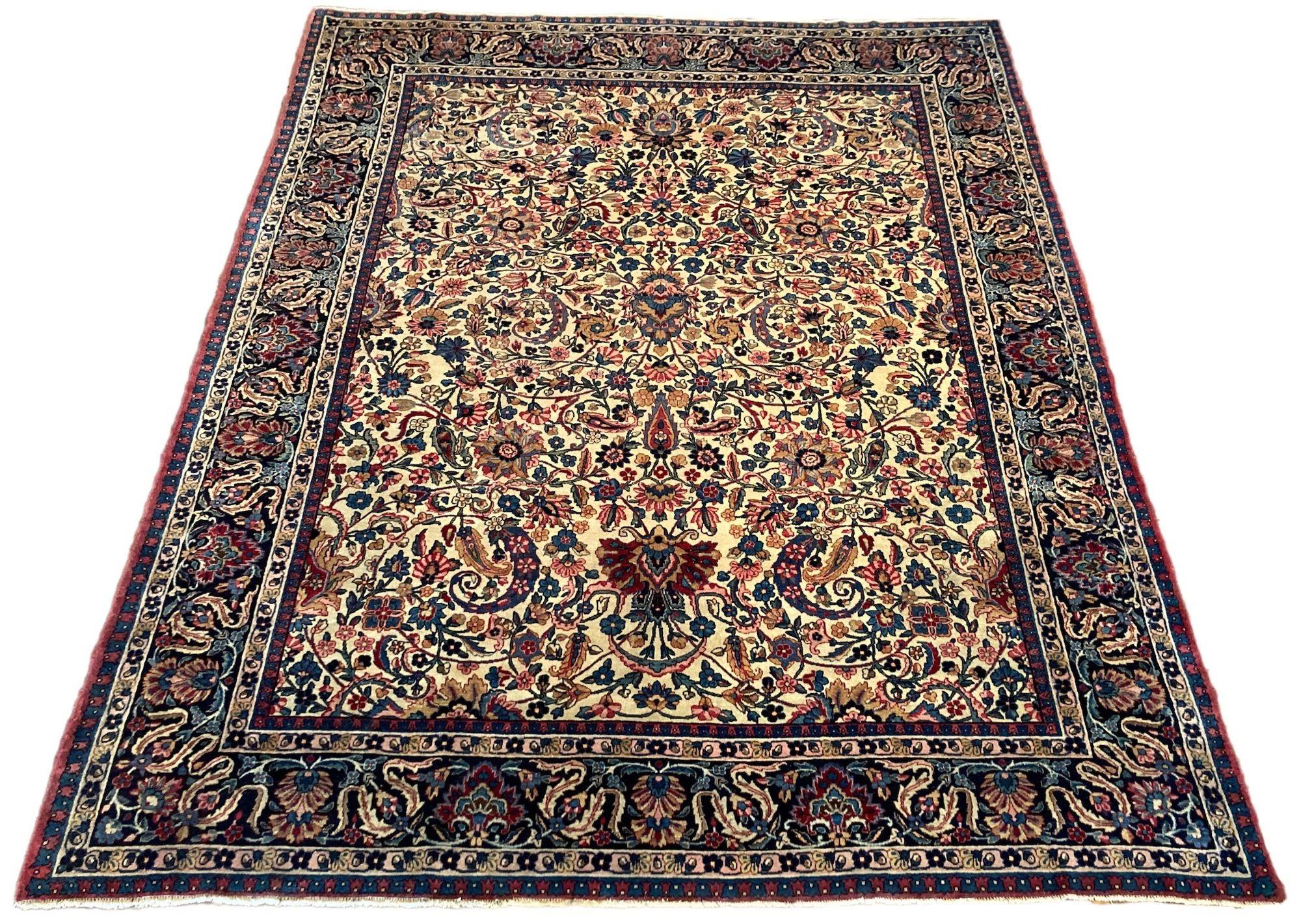 A fabulous antique Kerman Lavar carpet, handwoven circa 1910 featuring an allover floral design on an ivory field and deep indigo border. Finely woven with soft, silk like wool and secondary colours of reds, pinks and gold.
Size: 2.94m x 2.41m (9ft