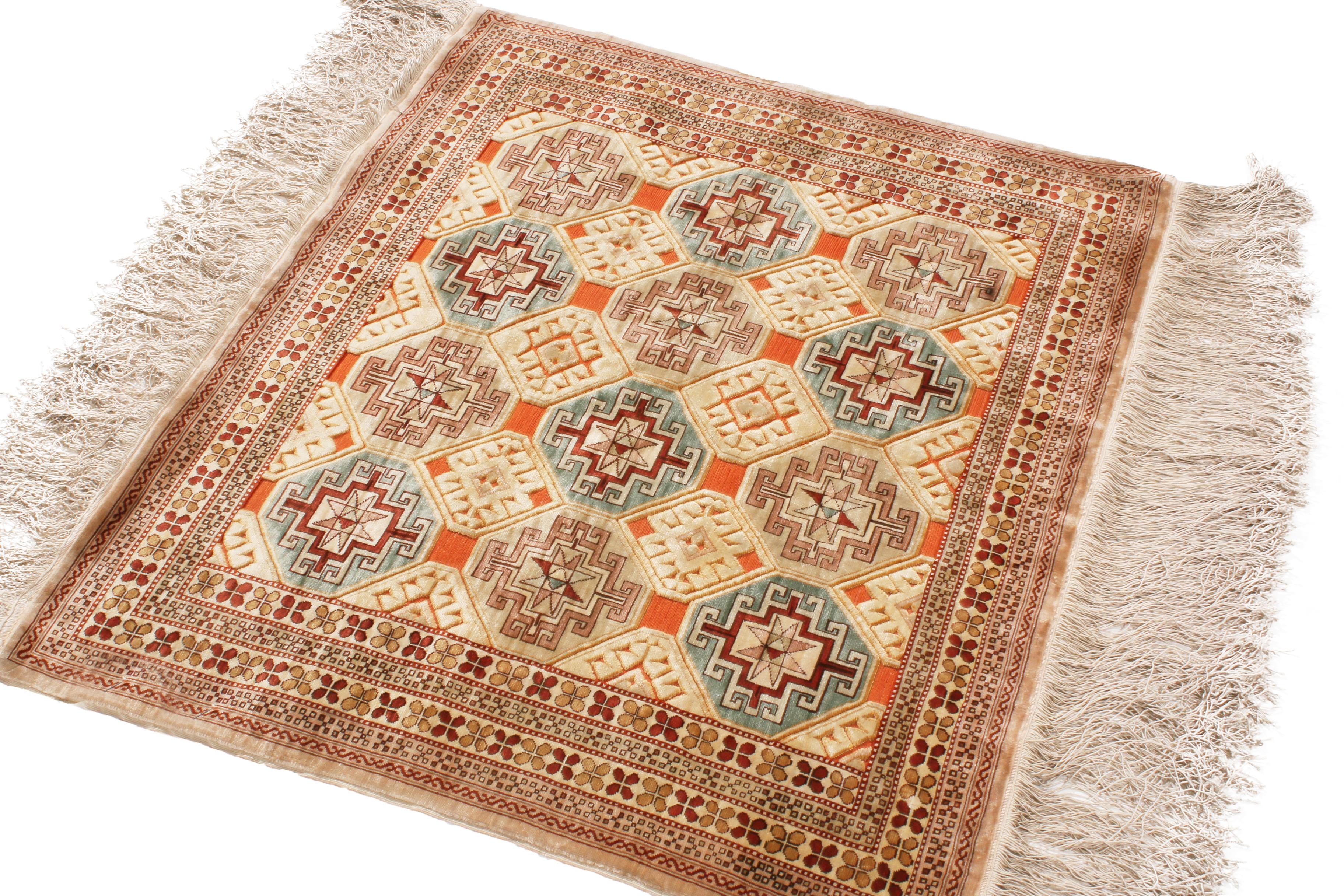 Enjoying a very tribal geometric-floral design and hand knotted, naturally luminous silk originating from Turkey in 1890, this antique Kirsehir rug is an ode to masterful symmetry in color and pattern, mirrored from the center outward in an