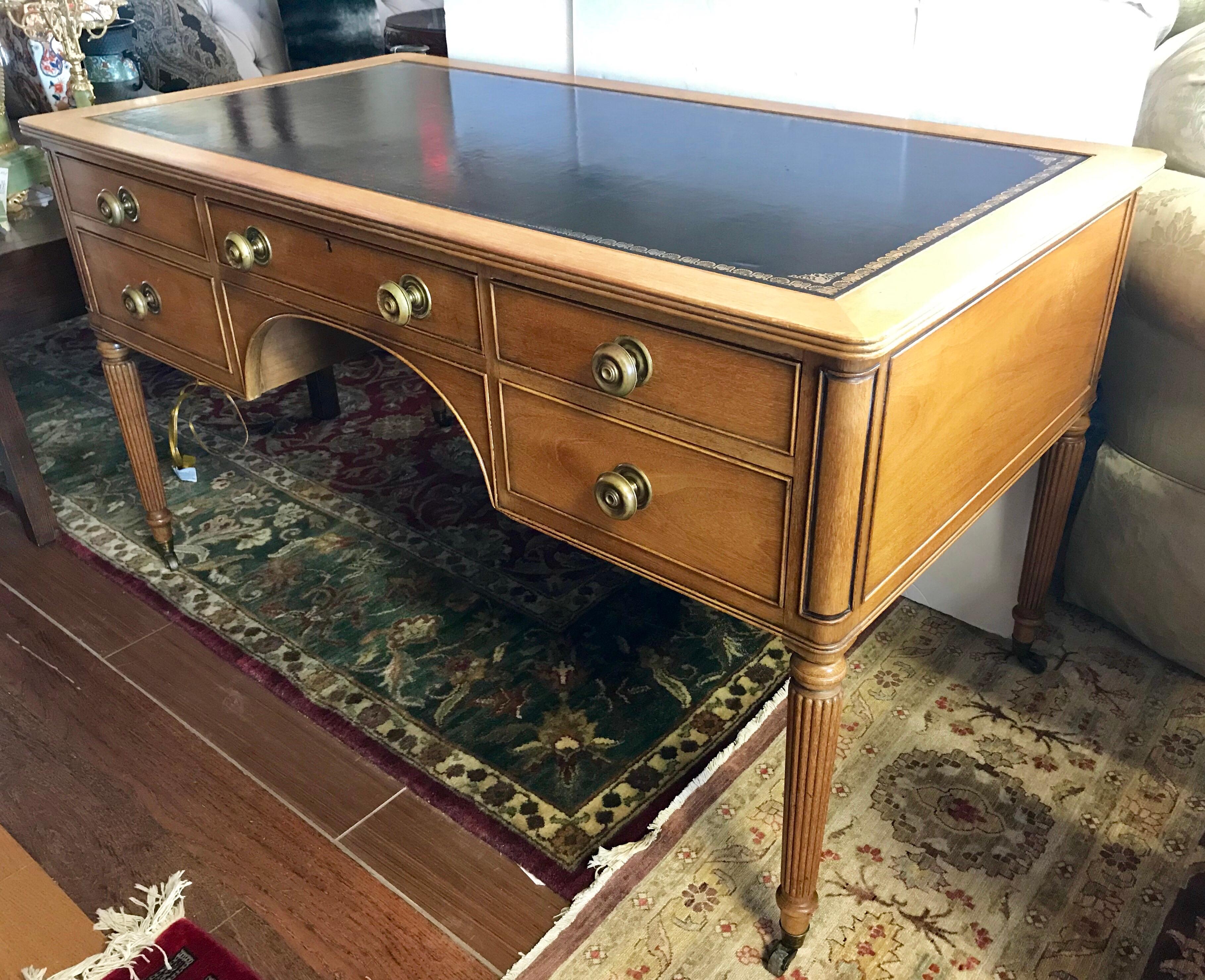 Rare signed Kittinger light colored fruitwood desk with black leather top and very unusual brass pulls throughout, including on both the back front of desk.