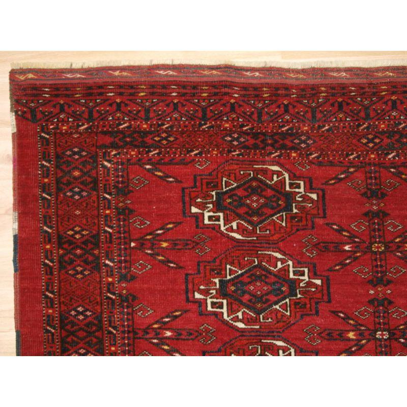 Antiker Kizil Ayak Ersari Turkmen 12 Gul Tschowal mit guter roter Grundfarbe. Das Elem-Design besteht aus stilisierten Sträuchern oder Blumen. Es gibt einige sehr schöne gelbe Highlights.

Die Guls sind gut gezeichnet und groß, die kleineren Guls