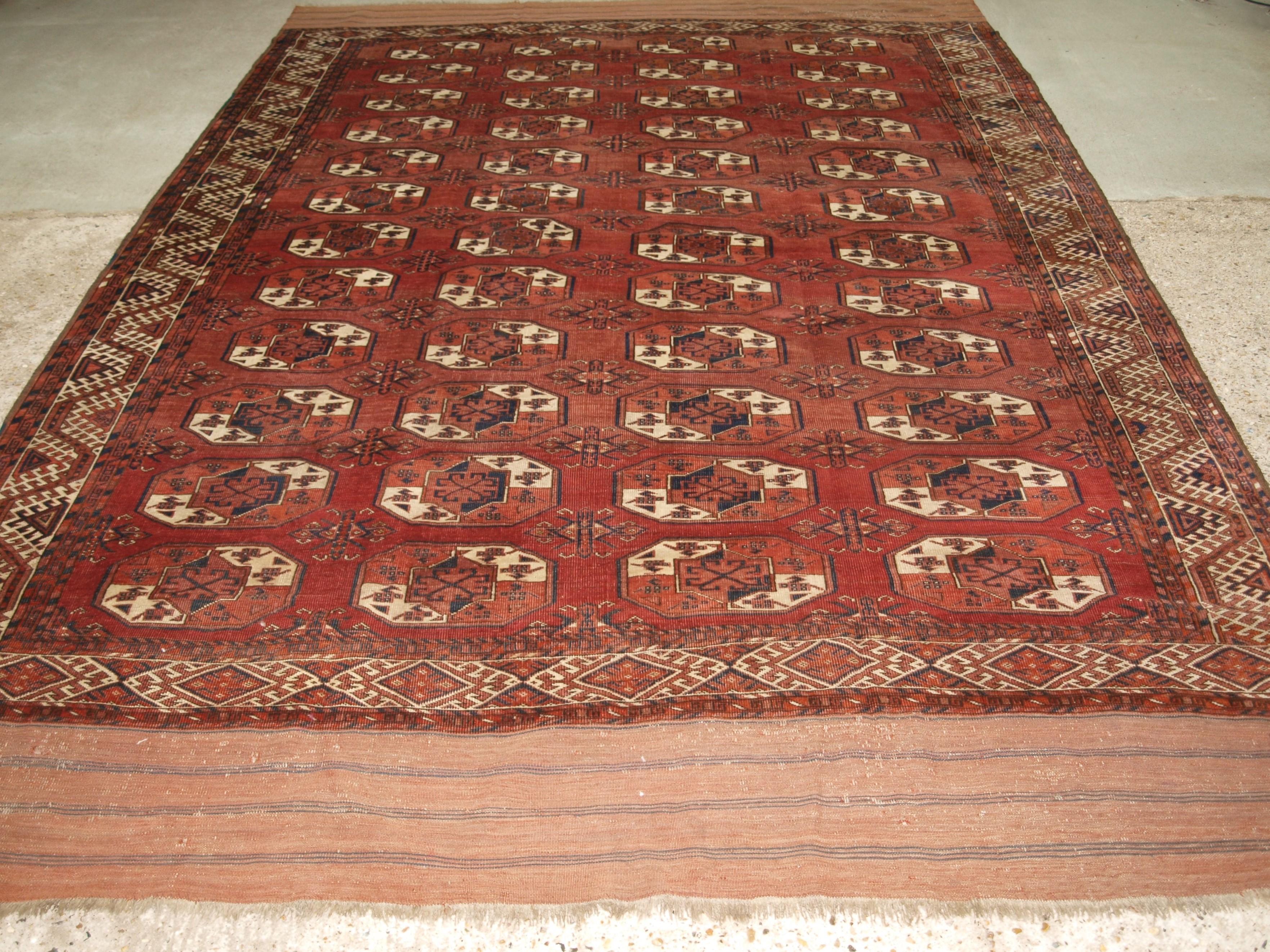 Antique Kizyl Ayak Ersari Turkmen main carpet with an unusual variant of the ‘tauk nuska’ gul design; each segment of the gul contains two bird heads or horned animals. The carpet has a soft red ground colour which gives the carpet a very warm look,