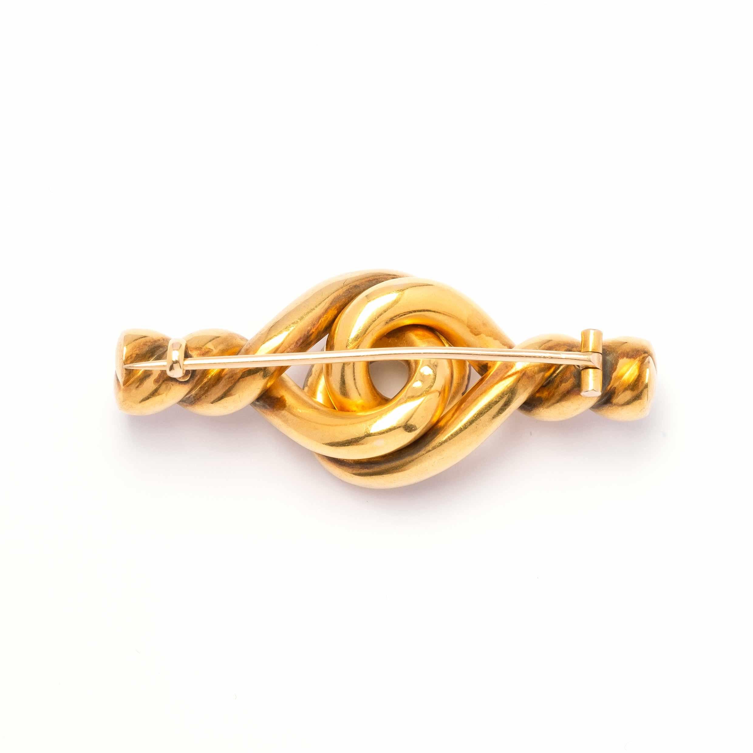 Antique knot brooch set in 18ct gold with rubies and rose cut diamonds. Second half of the 19th Century.

Highlights:
- 18ct gold
- Rubies and rose cut diamonds
- Second half of the 19th Century

Measurements
- Length 2.3cm x width 5.5cm
- Weight: