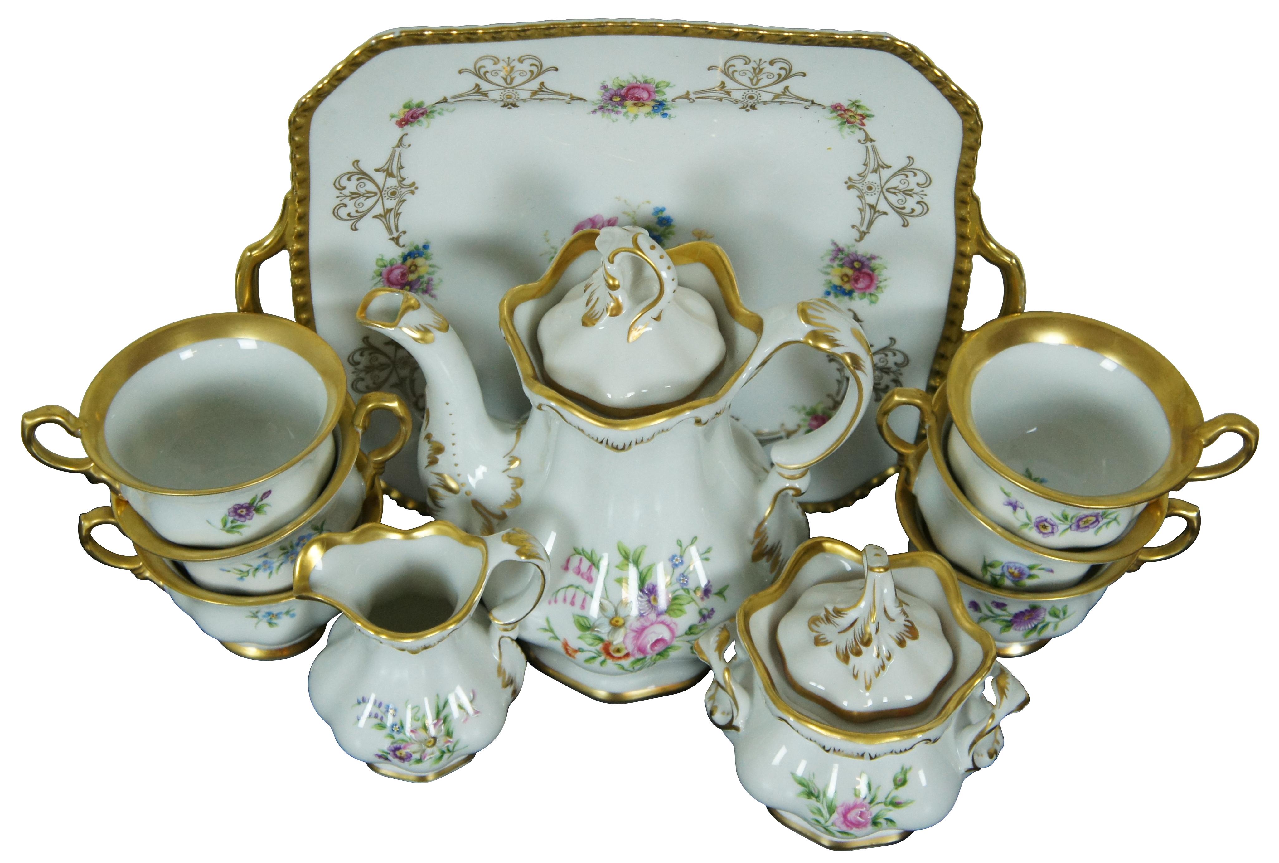 Early to mid 20th century exquisite twelve piece gilded floral tea set including a lidded teapot, creamer, lidded sugar bowl, six teacups, and dessert serving tray. Dessert tray by Royal Bayreuth Bavaria. Tea set by Kobenhavns Porcellains Maleri.