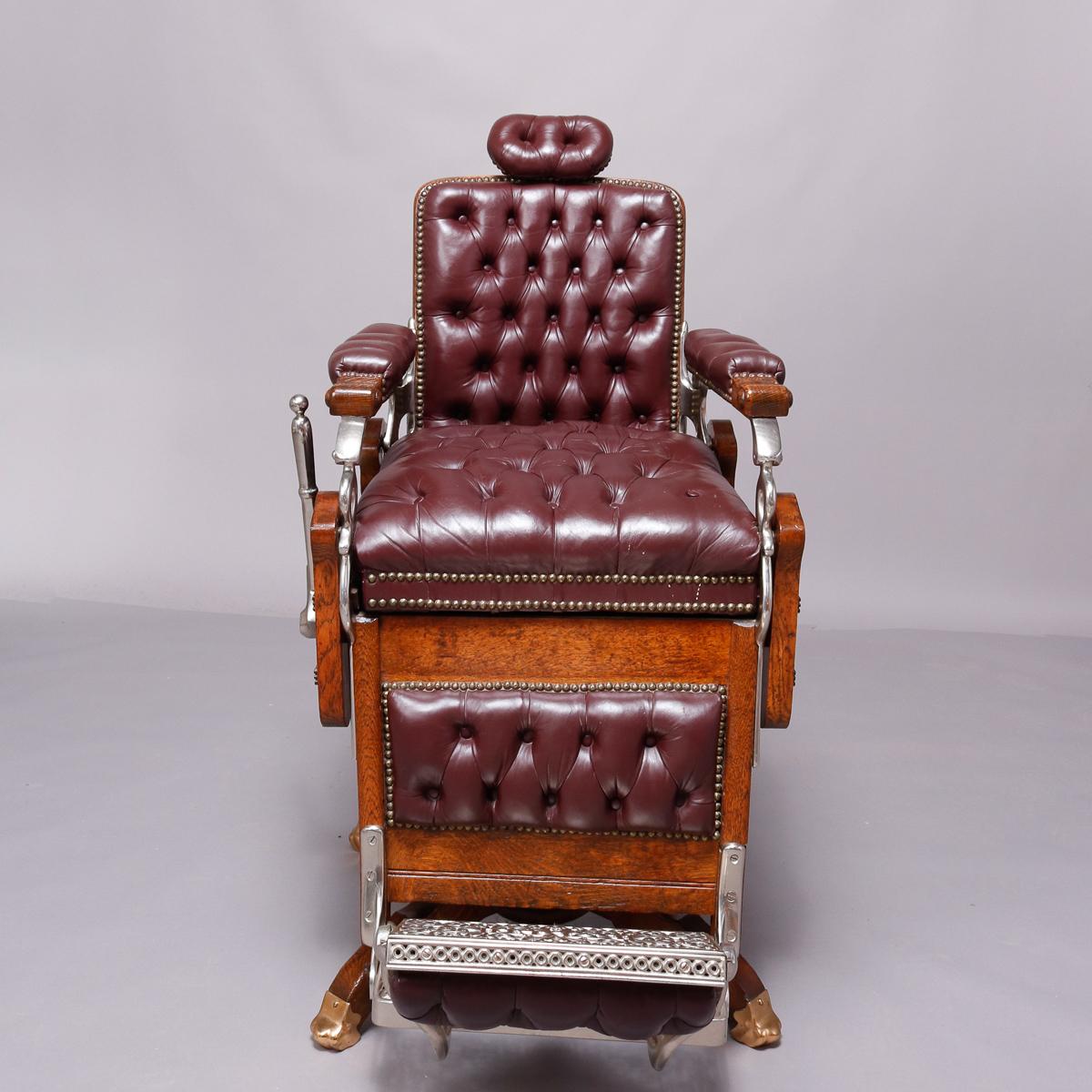 An antique and restored swivel, reclining and footed barber chair by Koken Barber Supply Co., St. Louis, MO offers quarter sawn oak frame having applied Fleur des Lis decoration with leather button back, seat, head and foot rests lined with brass