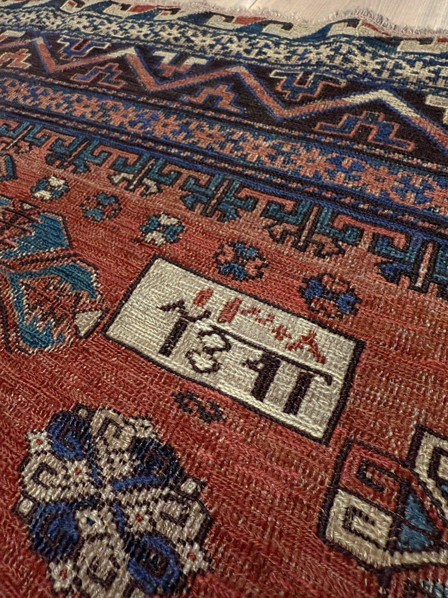 Dieser handgefertigte antike kaukasische Soumak-Teppich ist eine visuelle Symphonie aus tiefem Indigo, Ziegelrot und einem Hauch von Elfenbein, die vor Energie und zeitlosem Charme sprühen.

Die achteckigen Medaillons tanzen wie kühne Ausrufe durch