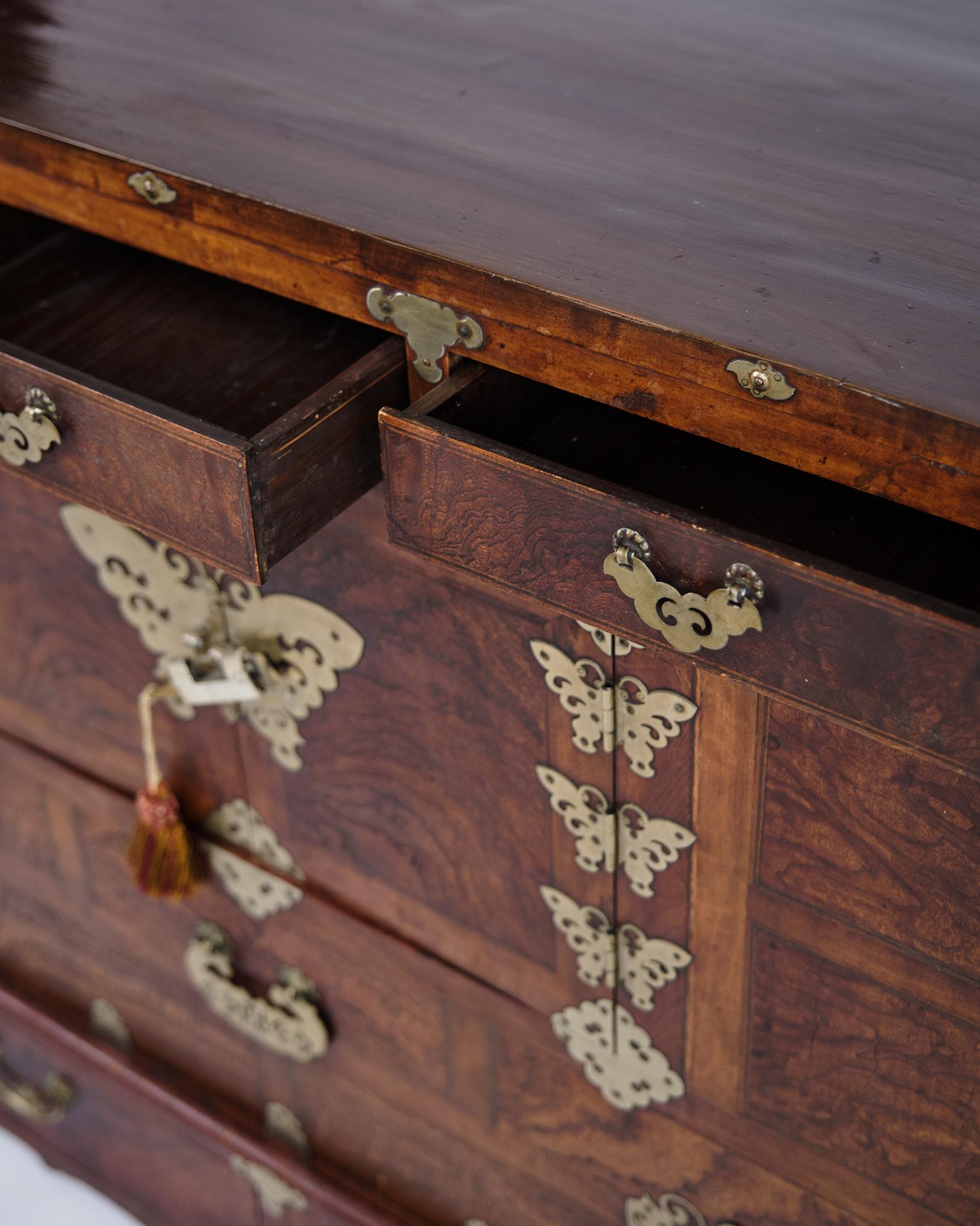 Antica cassapanca/vestito coreano Bandaji del 1900, tradizionalmente utilizzata come cassapanca nuziale. Realizzato in legno scuro con accessori decorativi in ottone, che evidenziano la maestria artigianale e la ricca storia culturale della