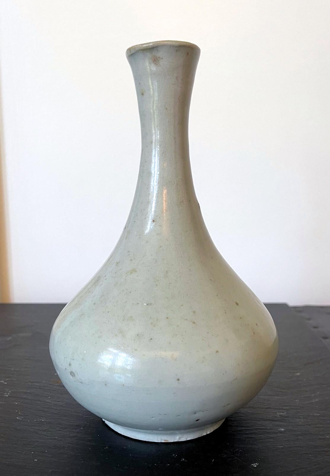 A Korean ceramic bottle vase circa 19th century late Joseon Dynasty (1392-1910), he smallest one in our the three bottles in our collection. The vase is of a classic bottle form with a bulbous body and a long neck with a slightly rolled mouth rum.