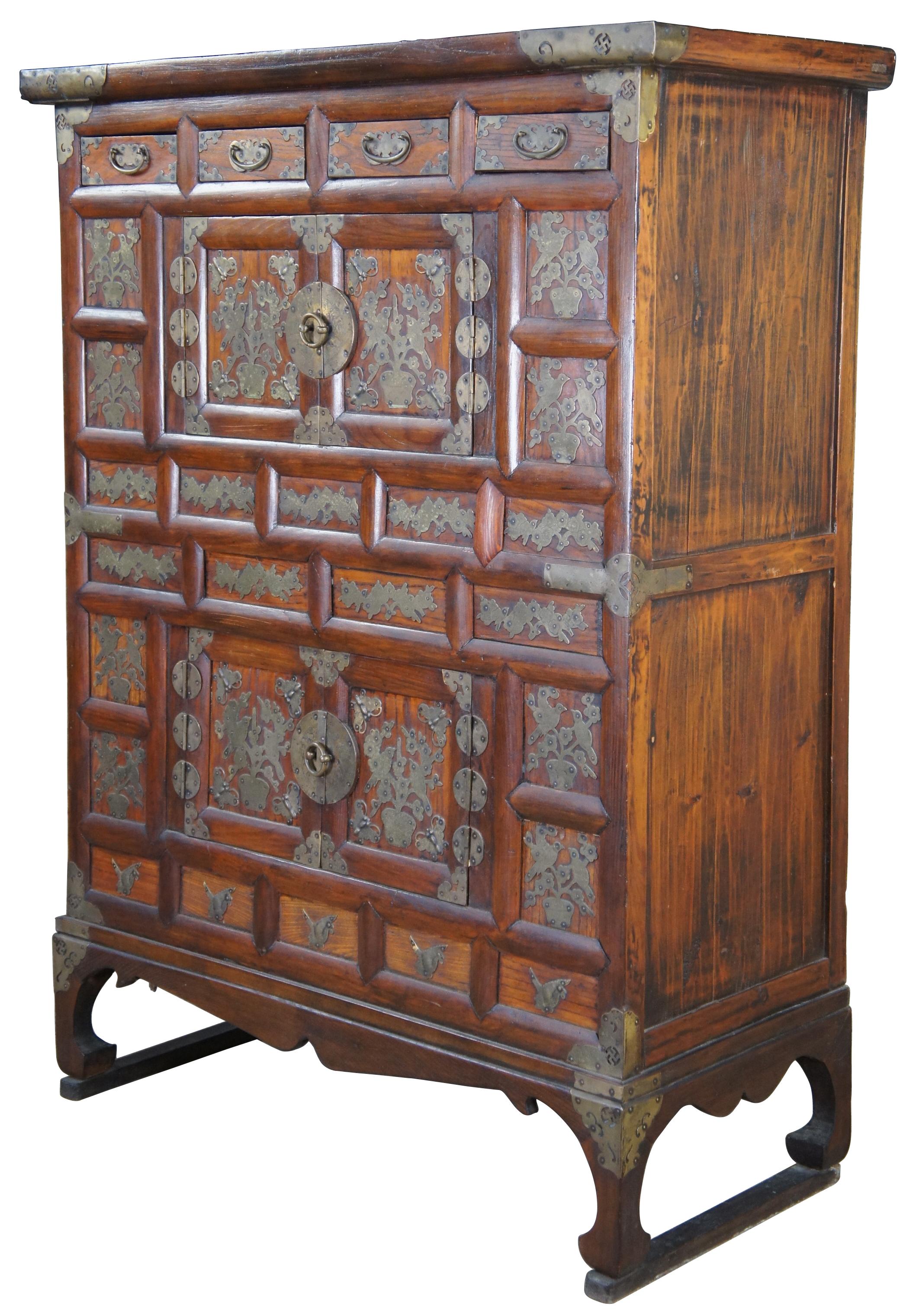Early 19th Century Korean Tansu Nong Bandaji wedding chests or cabinet made of elmwood featuring ornate brass bird, butterfly and sawastika accents. The swastika symbol, ? (right-facing or clockwise) or ? (left-facing, counterclockwise, or