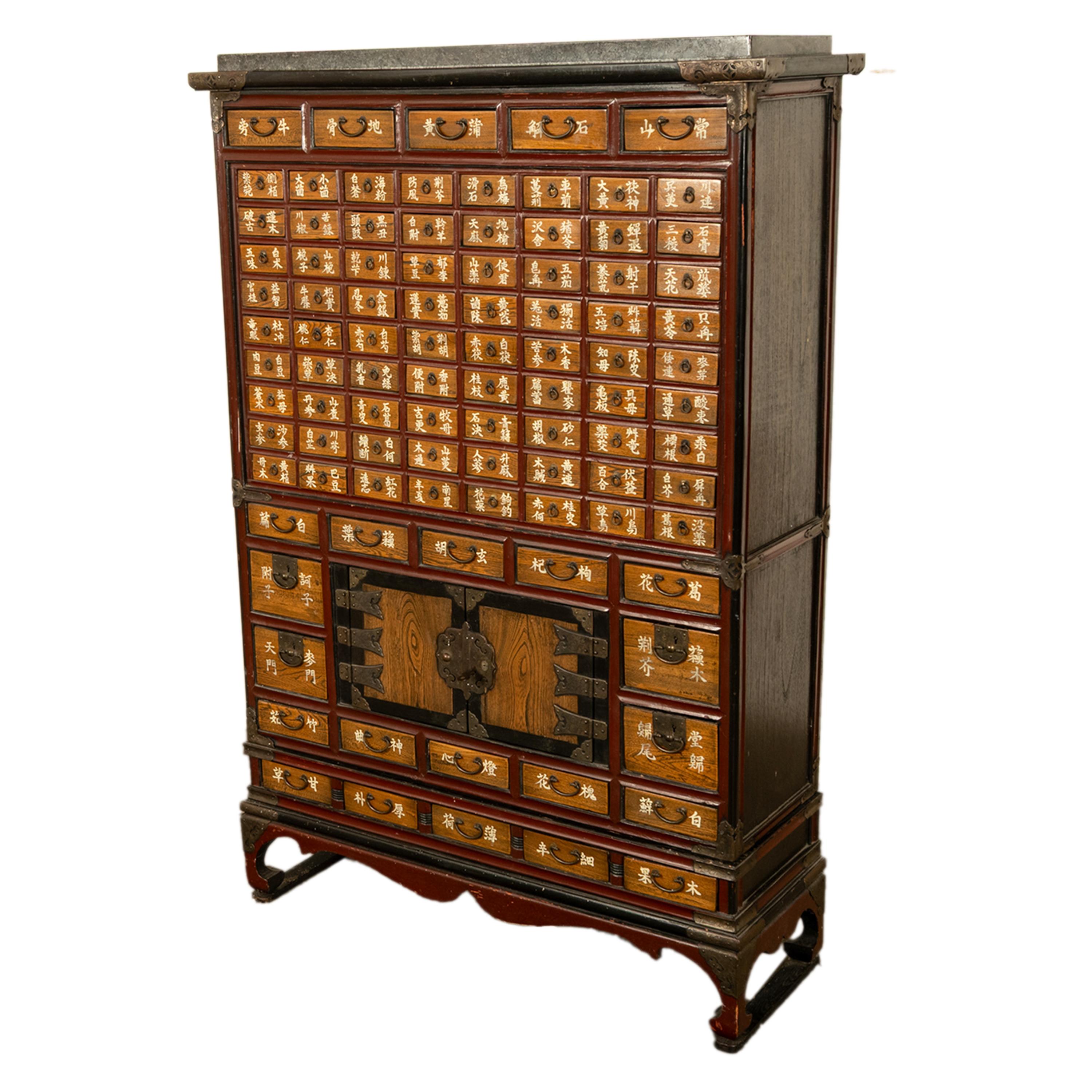 A good antique elm Korean medicine apothecary chest/cabinet, or Yakjang, circa 1920.
The cabinet is in two sections, the top is fitted with a piece of granite to place vessels and medicines when taken from one of the many drawers, the corners of the