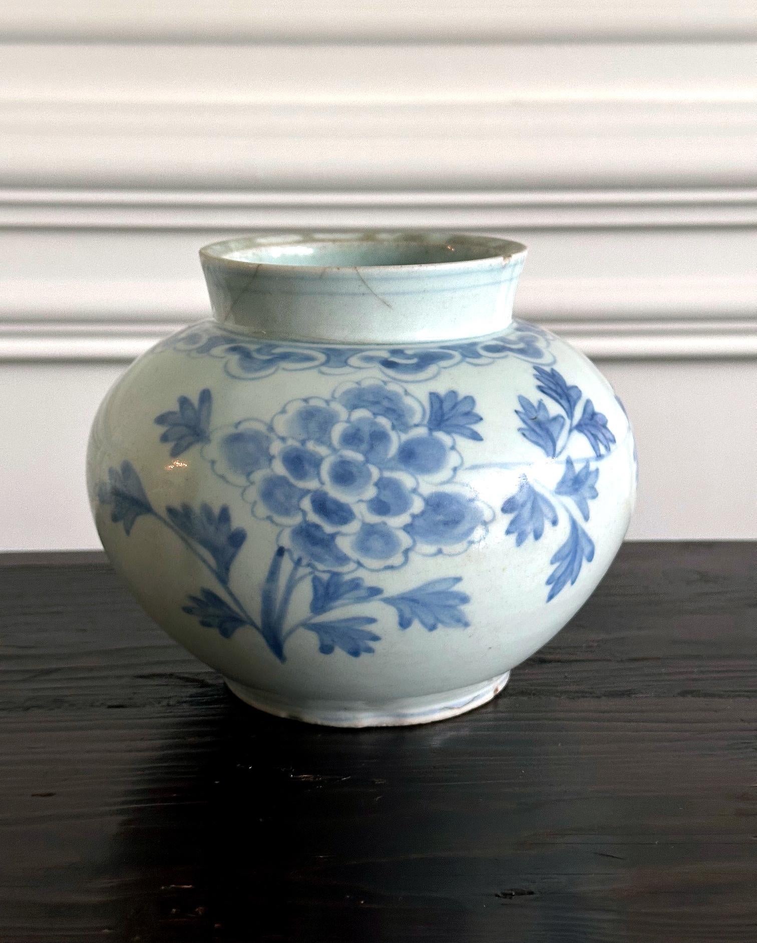 A Korean white porcelain jar with underglaze blue painting of large peonies with leaves circa second half of 19th century, Joseon Dynasty. Considered associated with Punwon-ri kilns in Gwangju, these types of globular jar with large mouth on a short