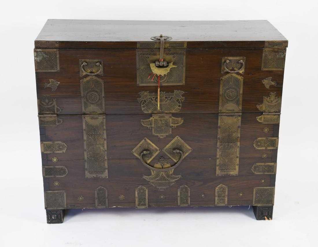 The antique Korean Bandaji, or blanket chest is handcrafted in wood and embellished with original brass trim, mounted with intricate fittings, including handles, hinges and lock plate. Chest has a drop front, used to store clothing and documents on