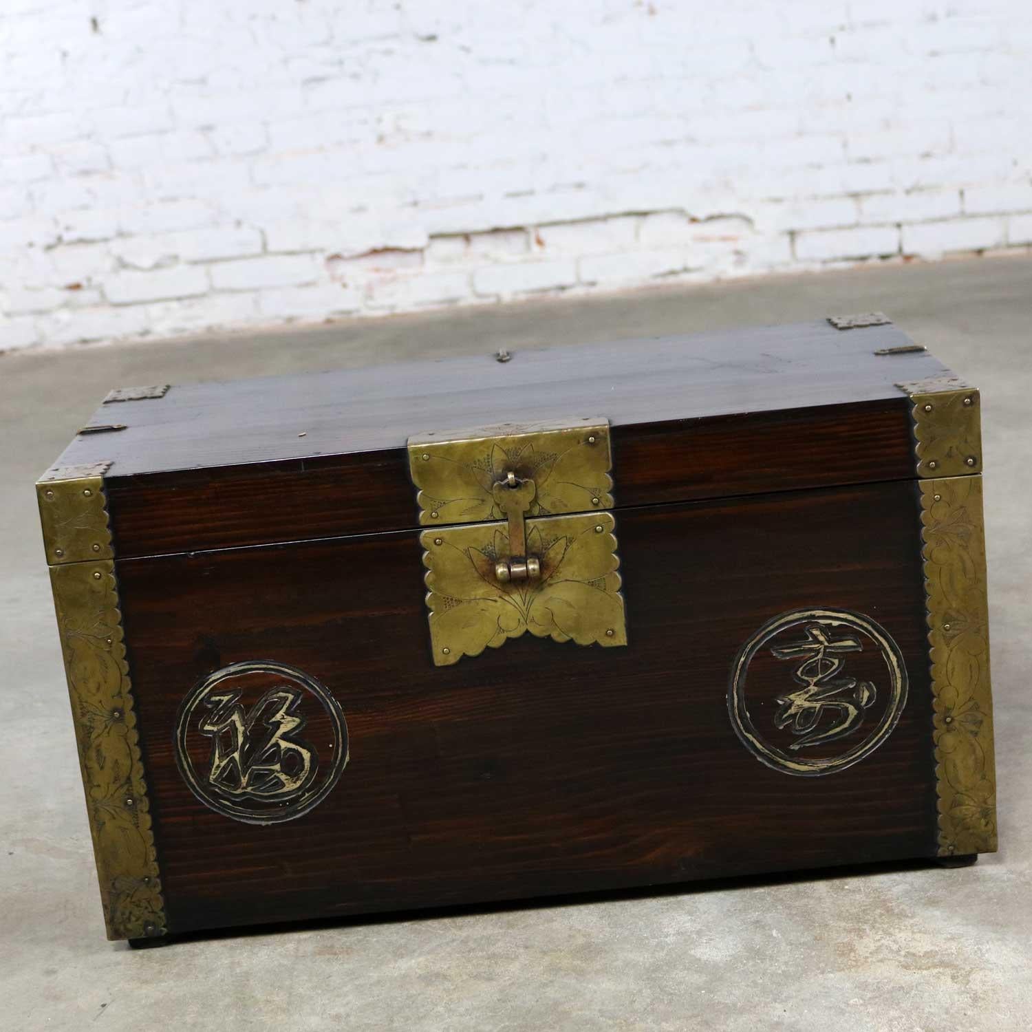 Handsome antique Korean trunk or chest with beautiful brass details and the auspicious Chinese characters for luck and longevity carved into the front. It is in wonderful antique condition with a nice age patina, circa early 20th century most likely