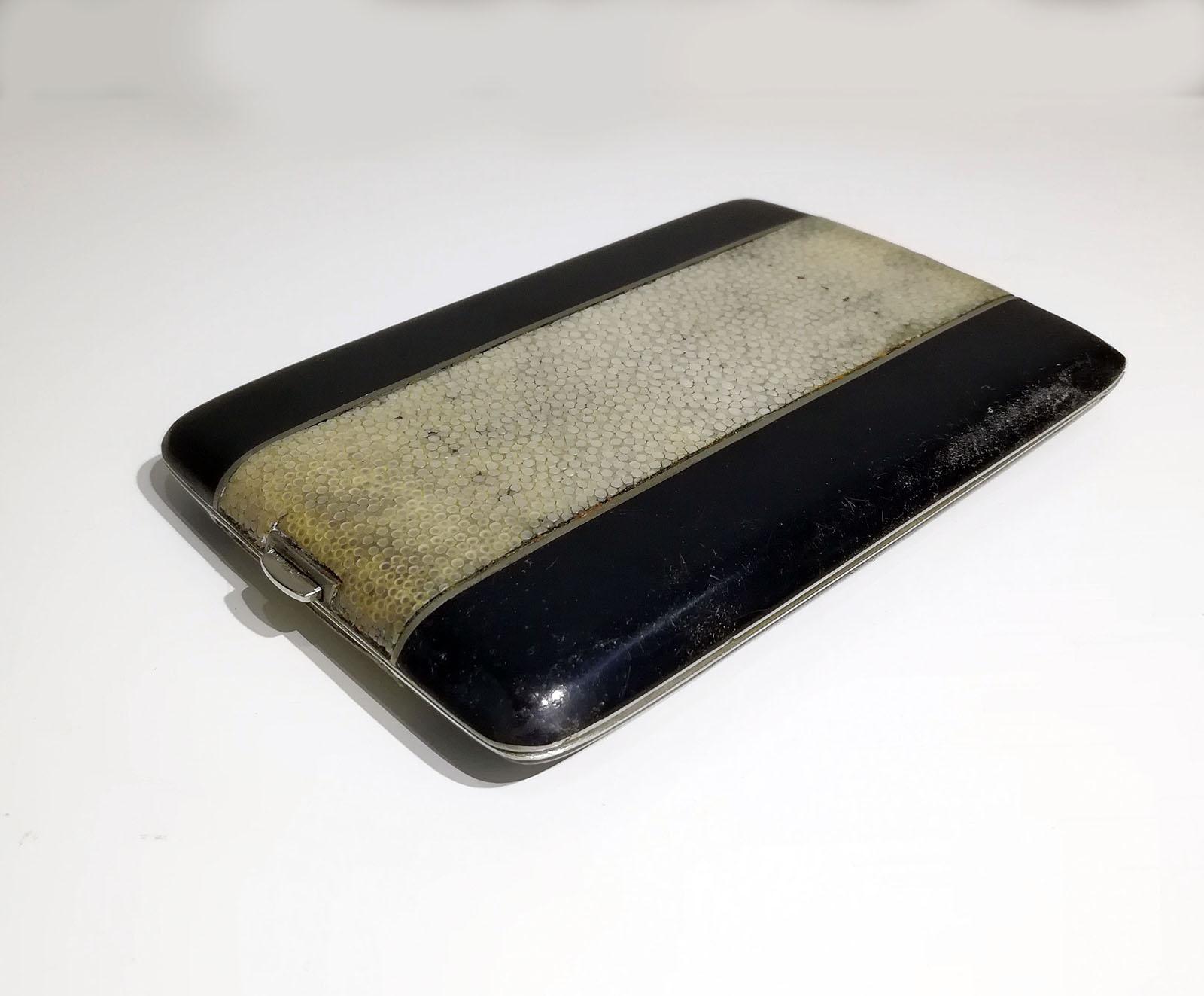 Black lacquered silver Cigarette case, has particularly lovely shagreen (GALUCHAT) band on the top. 
Stamped “Kraft Al Pacca” and “Argent” from the inside.
The wonderful Galuchat makes it one of the few and most beautiful examples of Art Deco