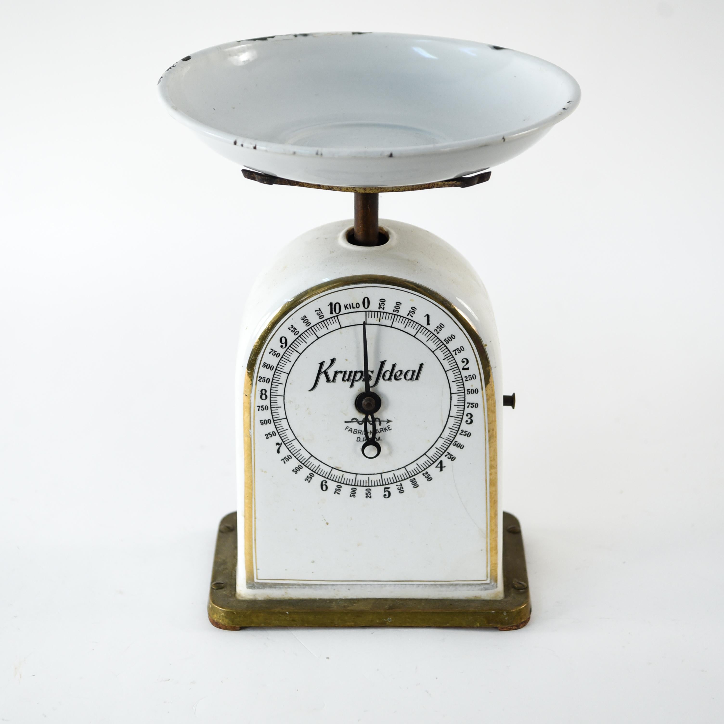 Cette balance du début du 20ème siècle est de la marque Krups Ideal et est marquée sur la face. Cette pièce ferait un charmant accent décoratif dans une cuisine ou une salle à manger.