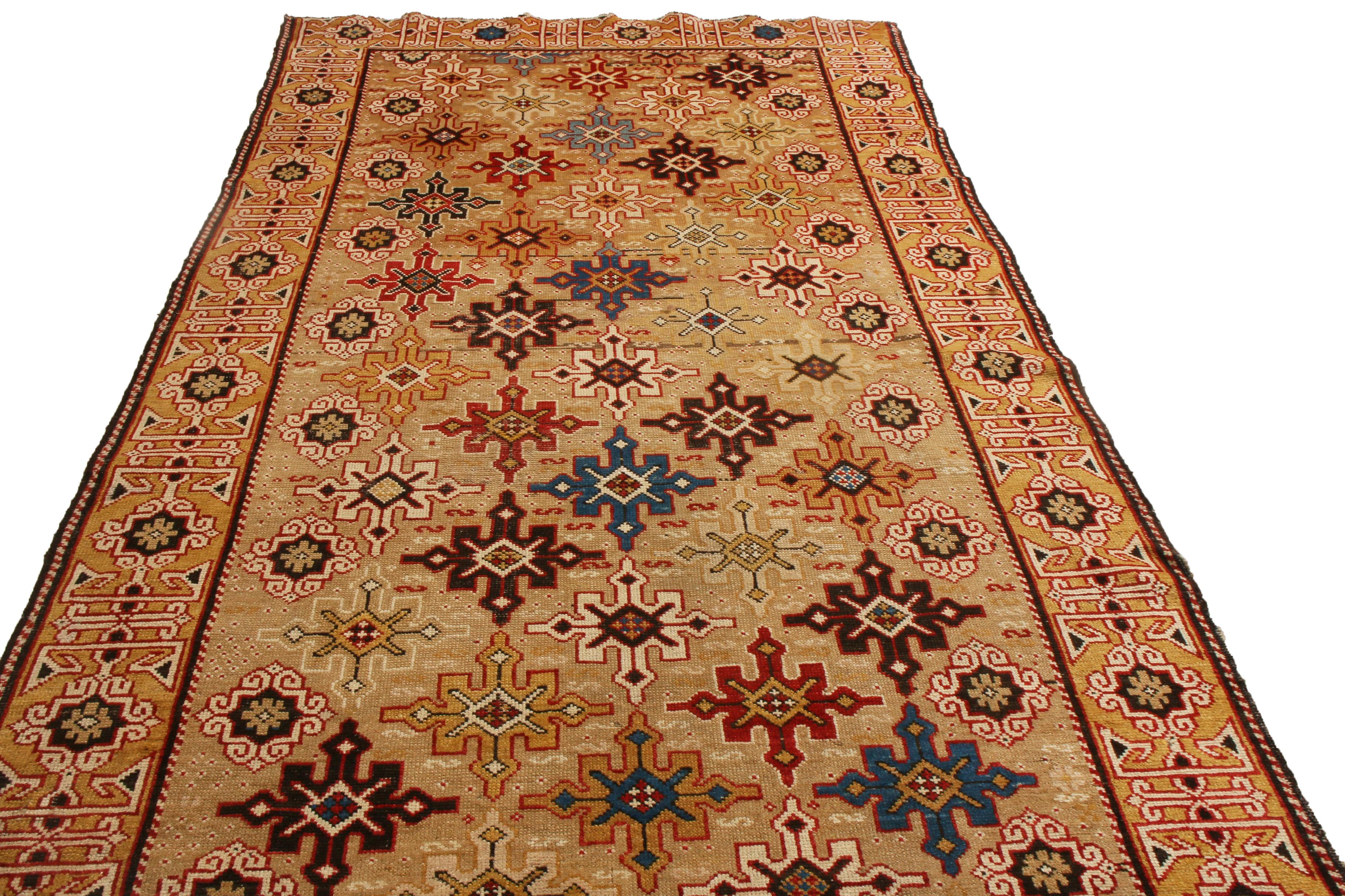 Originating from Russia between 1880-1890, this antique geometric runner enjoys a wrapping border and unique Kuba field design characterized by repeating crimson, blue, black, tan, and golden-yellow eight-pointed stars against an exceptionally rare,