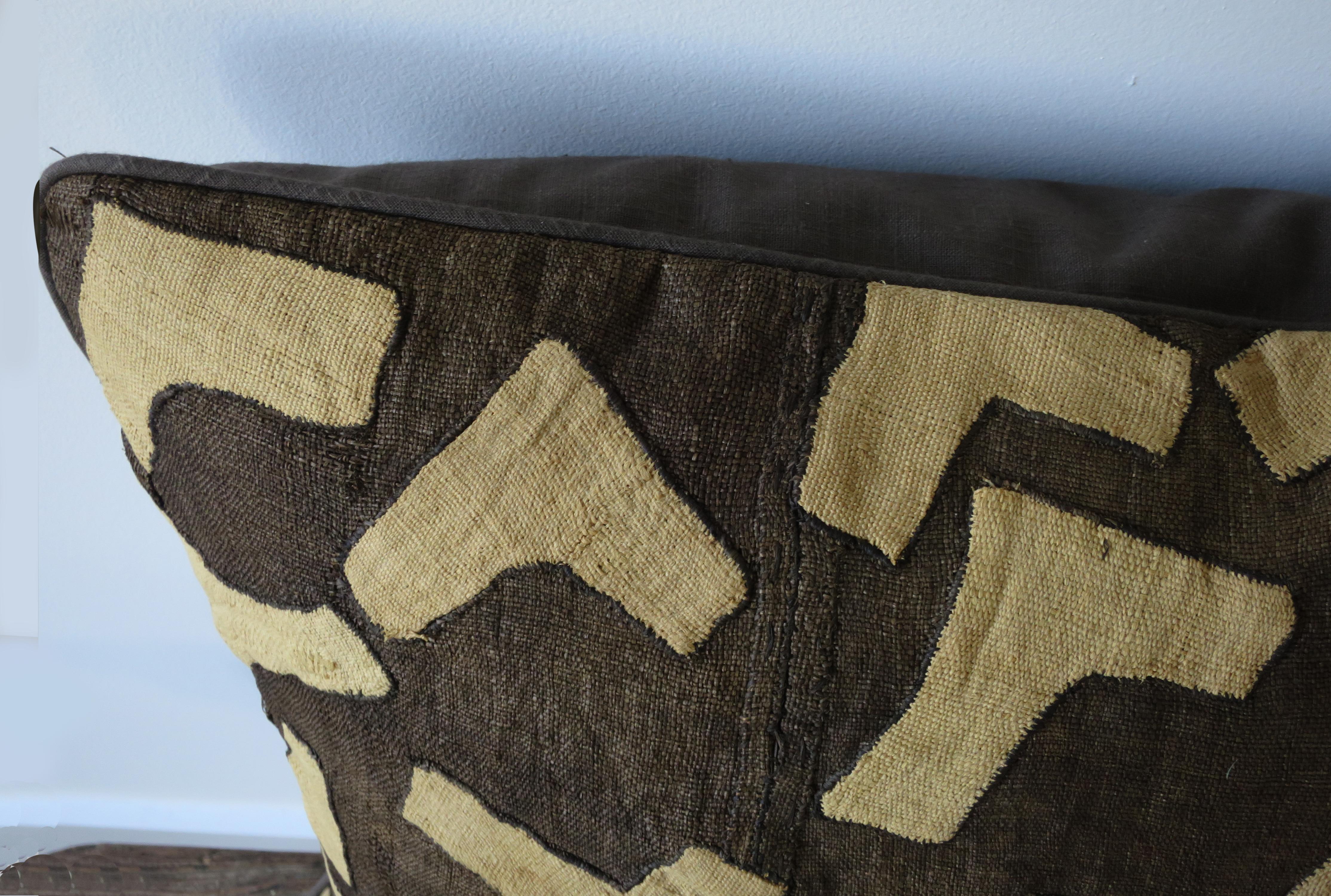 Originally part of an 8-panel length of raffia cloth, used in the Congo as a ceremonial skirt.
Backed in linen, with all down stuffing.
Light tan bold graphic shapes on a dark brown ground.
Eight pillows, each different design, available.