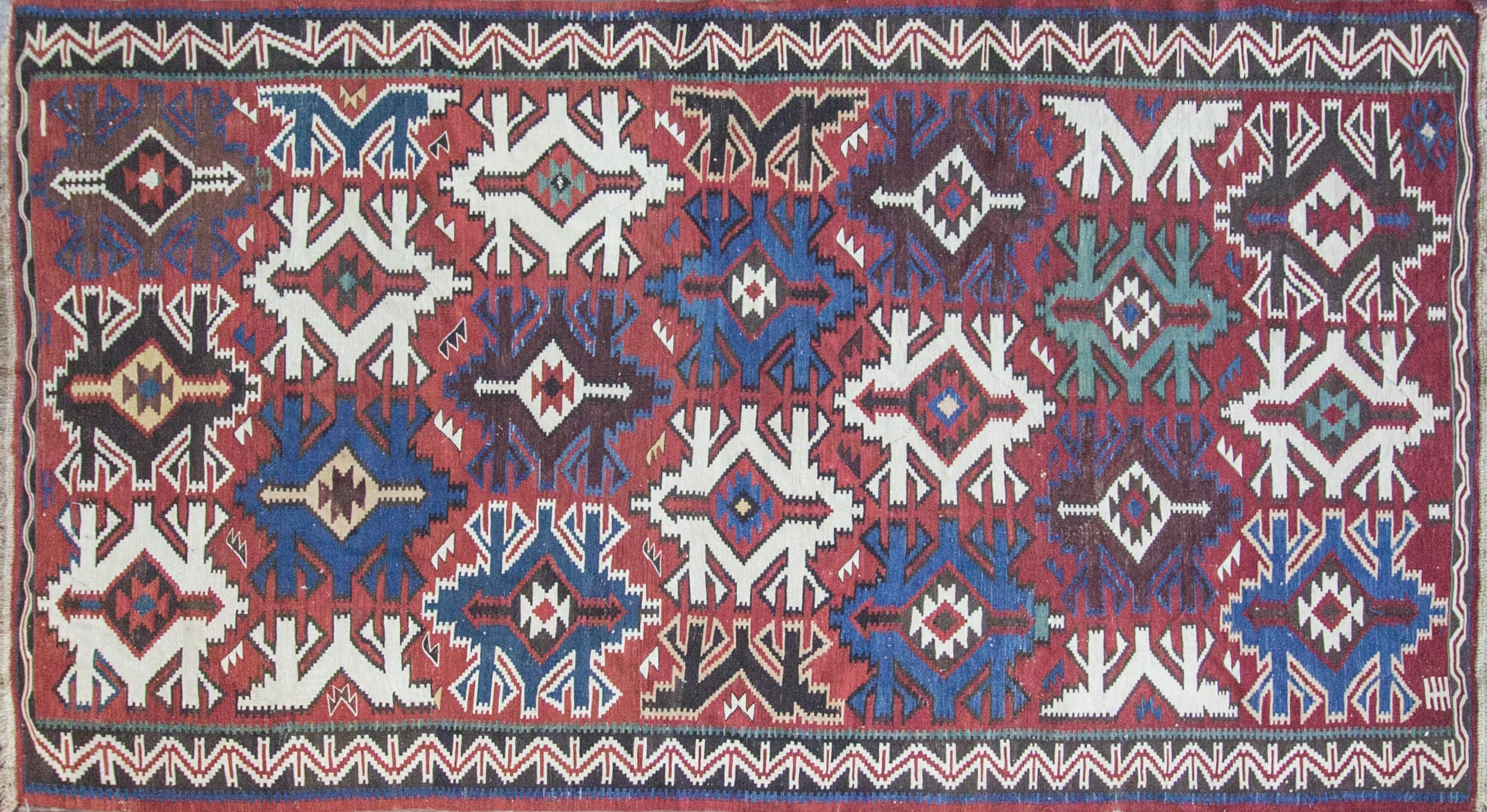 Antique Kilim long carpet, Kuba, late 19th century. An impressive staggered design of serrated palmette set against a blue field on this magnificent antique Kuba Kilim or great classical carpets of the Caucasus. The smaller palmettes and rosettes