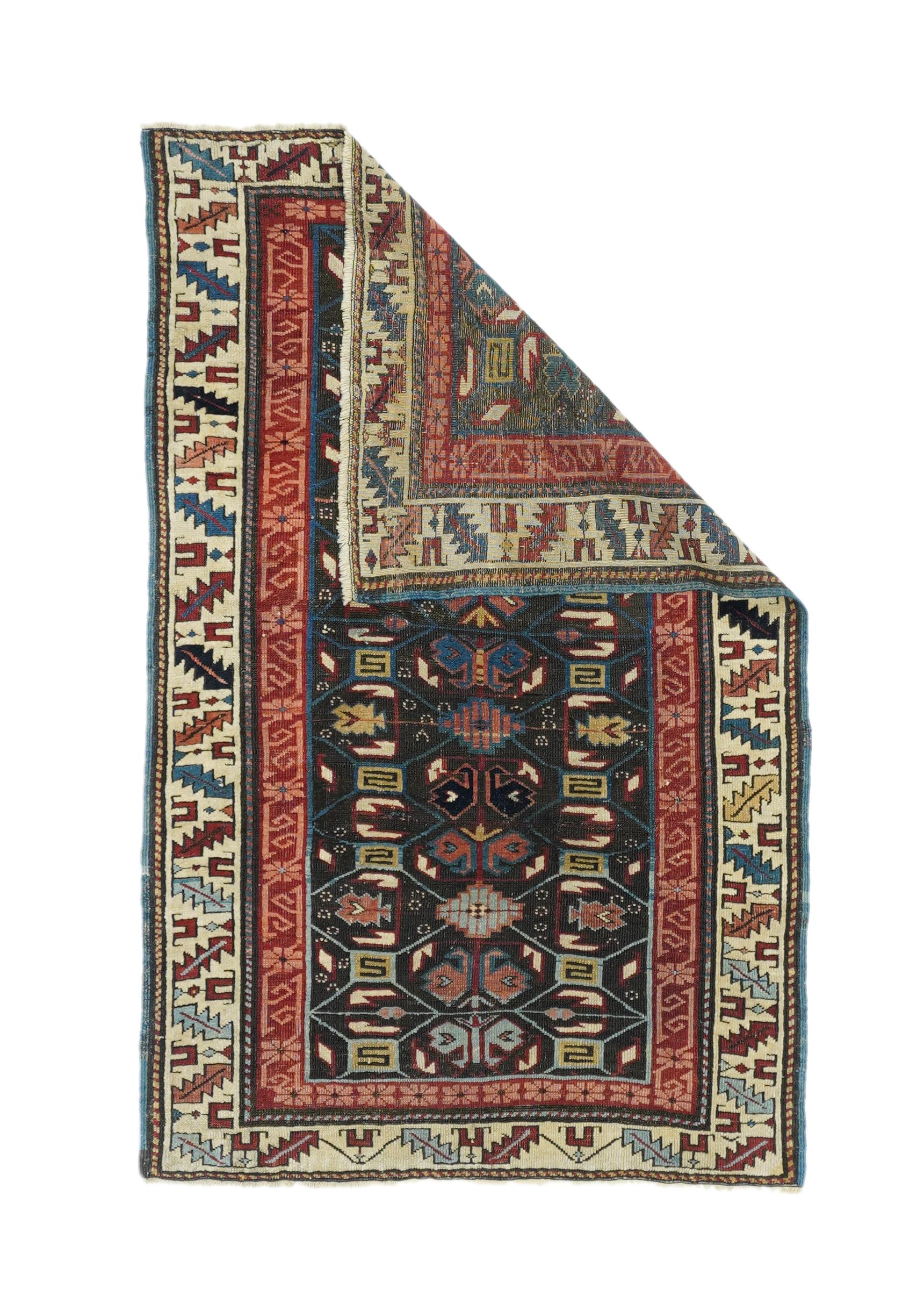 Antique Kuba rug 2'10'' x 4'5''. The dark red field displays five deeply serrated stacked lozenges in old gold, ecru, teal blue, charcoal and red, with ivory supporting stars. Teal blue border of wedge 