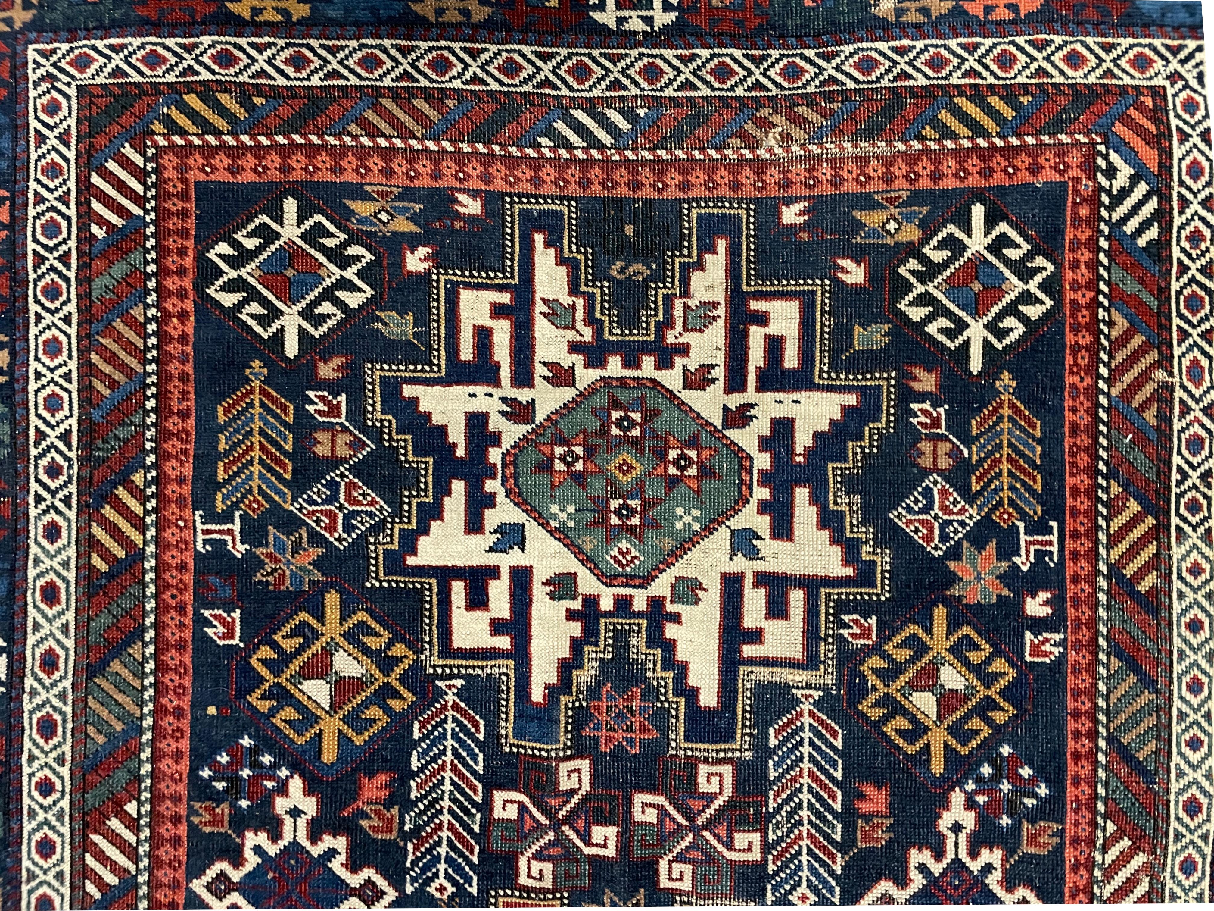 
Antique Kuba Rug
The center blue ground field with three large star-like motifs centered by multiple geometric medallions, with numerous narrow borders each with repeating geometric devices. 
76 in. by 42 in. (193.04 x 106.68 cm.) (wear and repairs