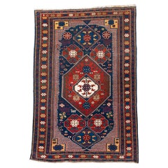 Tapis Kuba ancien dans les tons médiévaux bleu et sangria