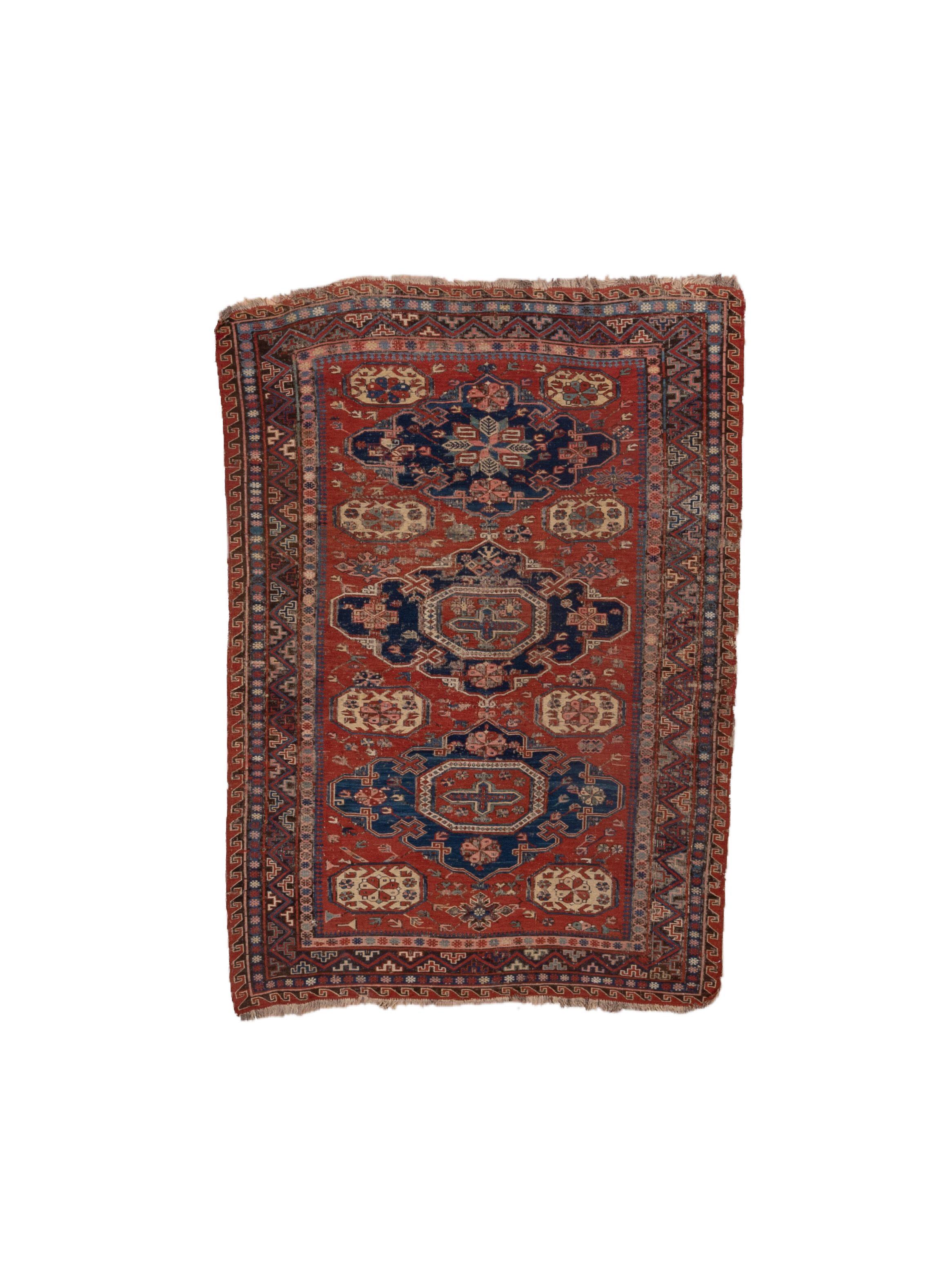 Le champ rouge vif présente le motif le plus populaire et le plus emblématique du sumac, composé de trois médaillons bleus réticulés avec des centres octogonaux et un cruciforme focal. Huit octogones de soutien en paille pâle dans le champ. Rosettes