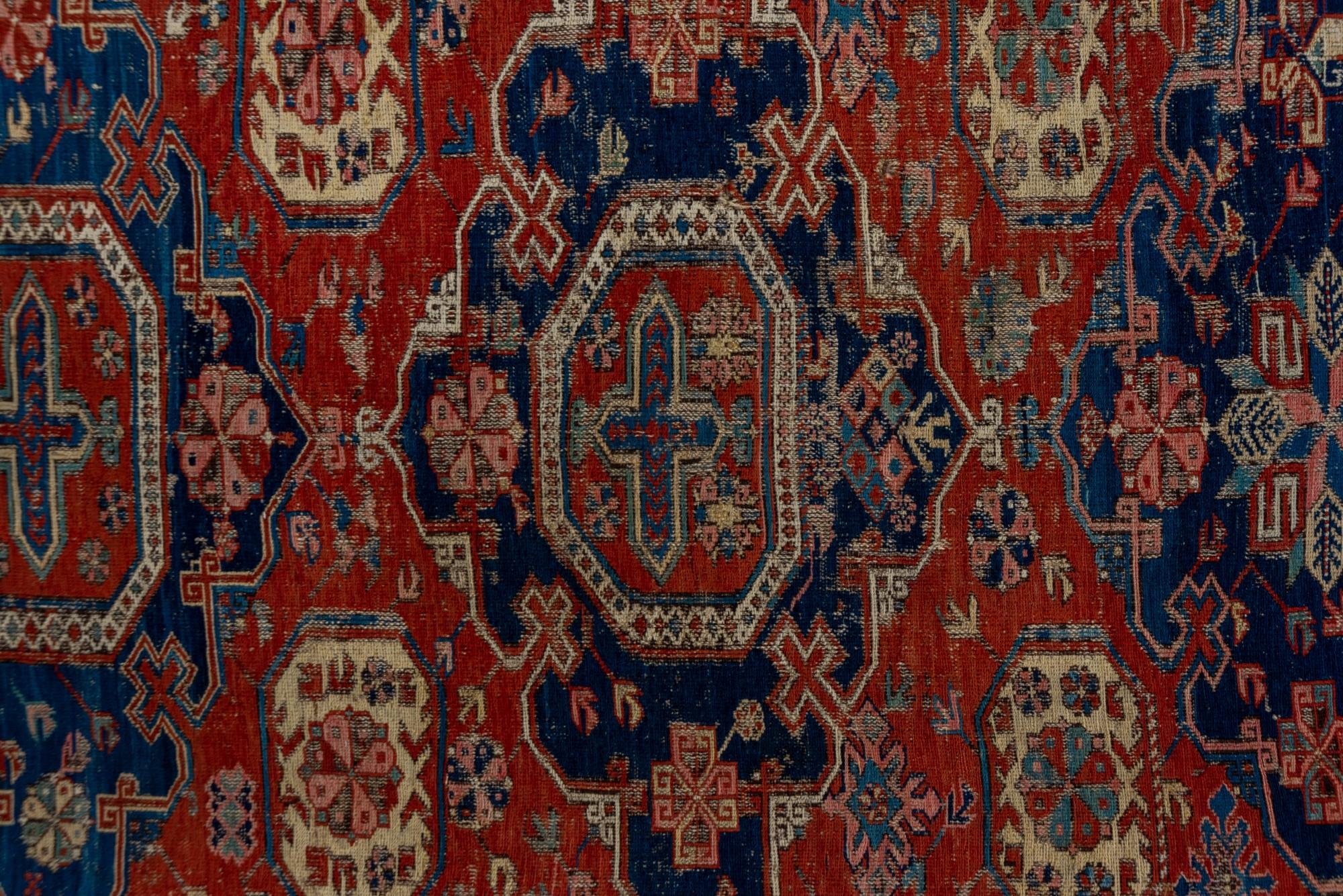 Noué à la main Tapis Kuba ancien avec champ rouge et motifs de rosettes en vente